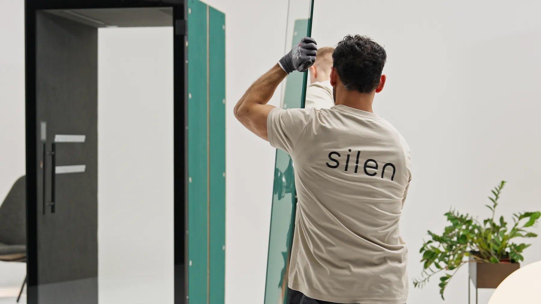 Technician fitting a glass panel onto a Silen pod frame