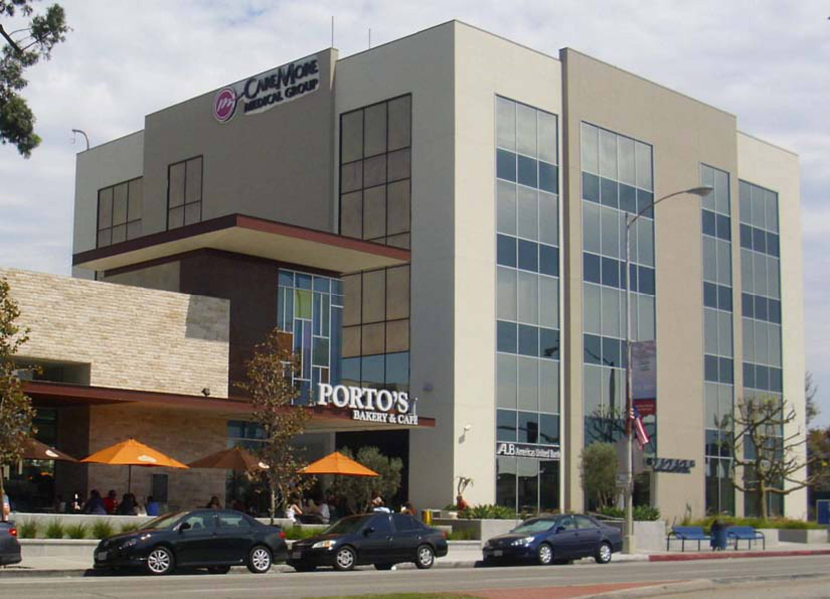 Exterior view of a modern multi-story medical office building with large windows and street parking.