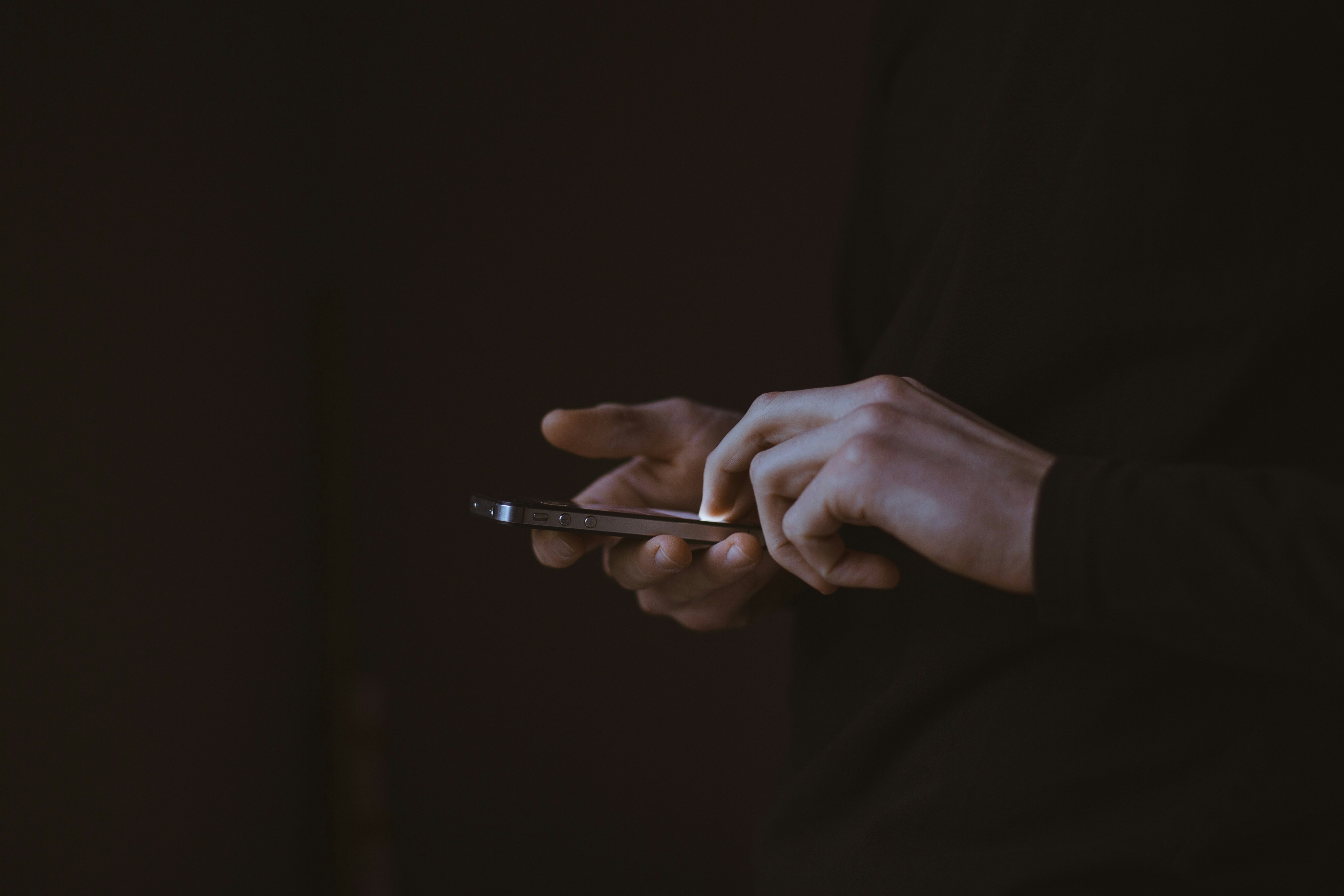 close of the hands of a person using their phone