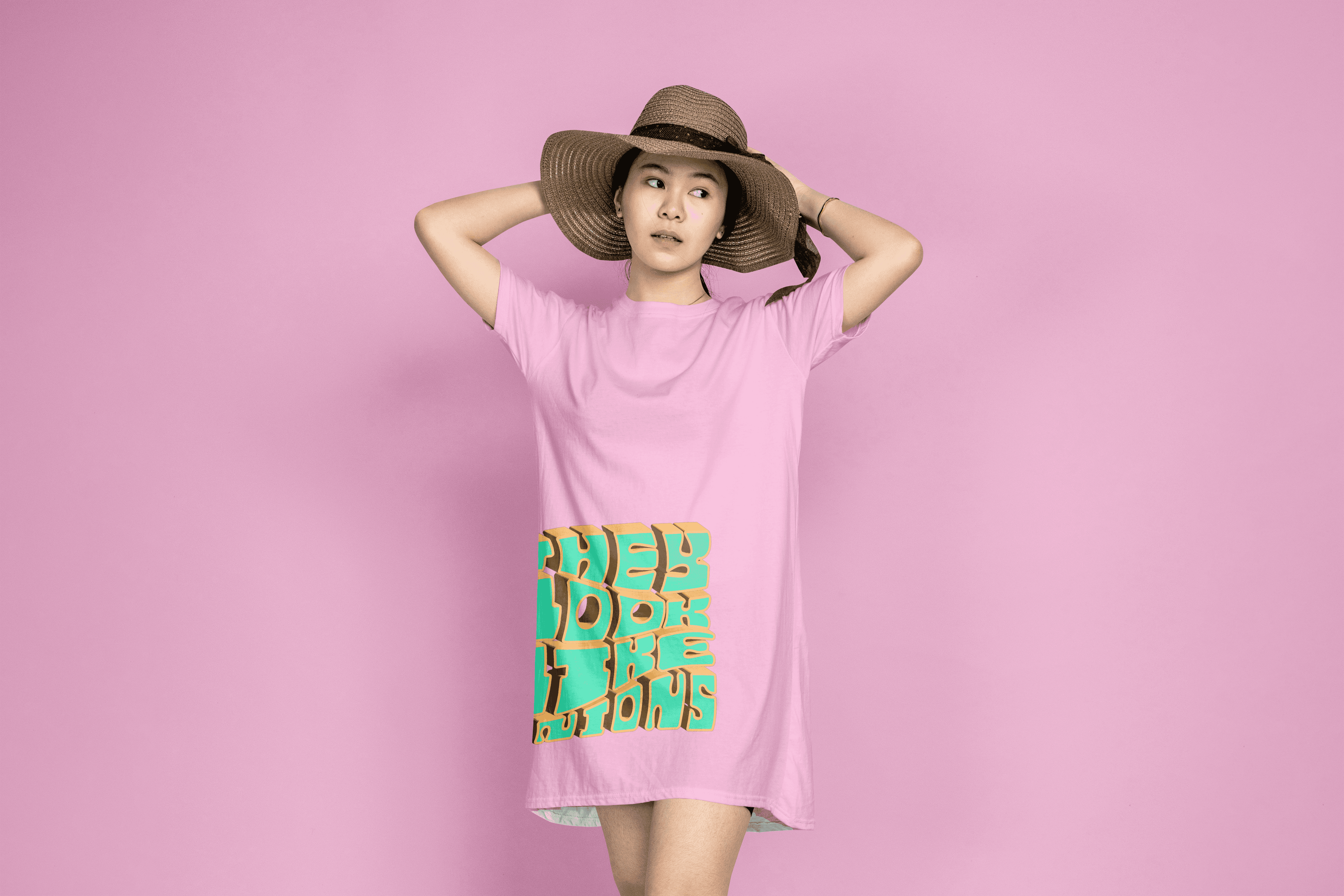 The green and gold digital 3D version of the piece mocked up on a pink t shirt being worn by a woman wearing a hat.