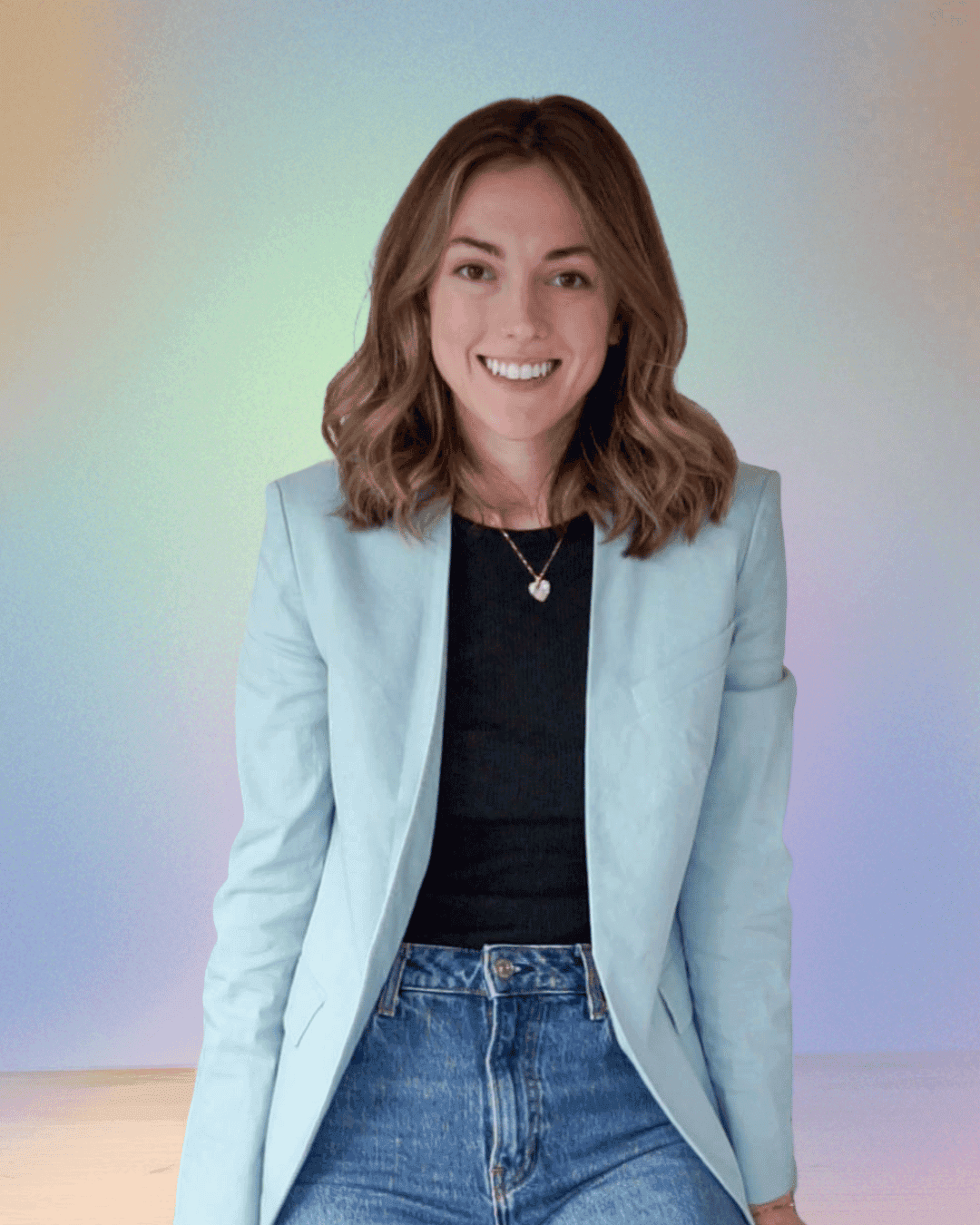 A young person with long, wavy hair sits in front of a plain background, looking directly at the camera.