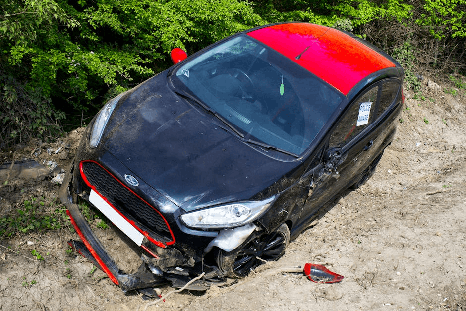 A black and red Ford Fiesta lies abandoned and damaged.