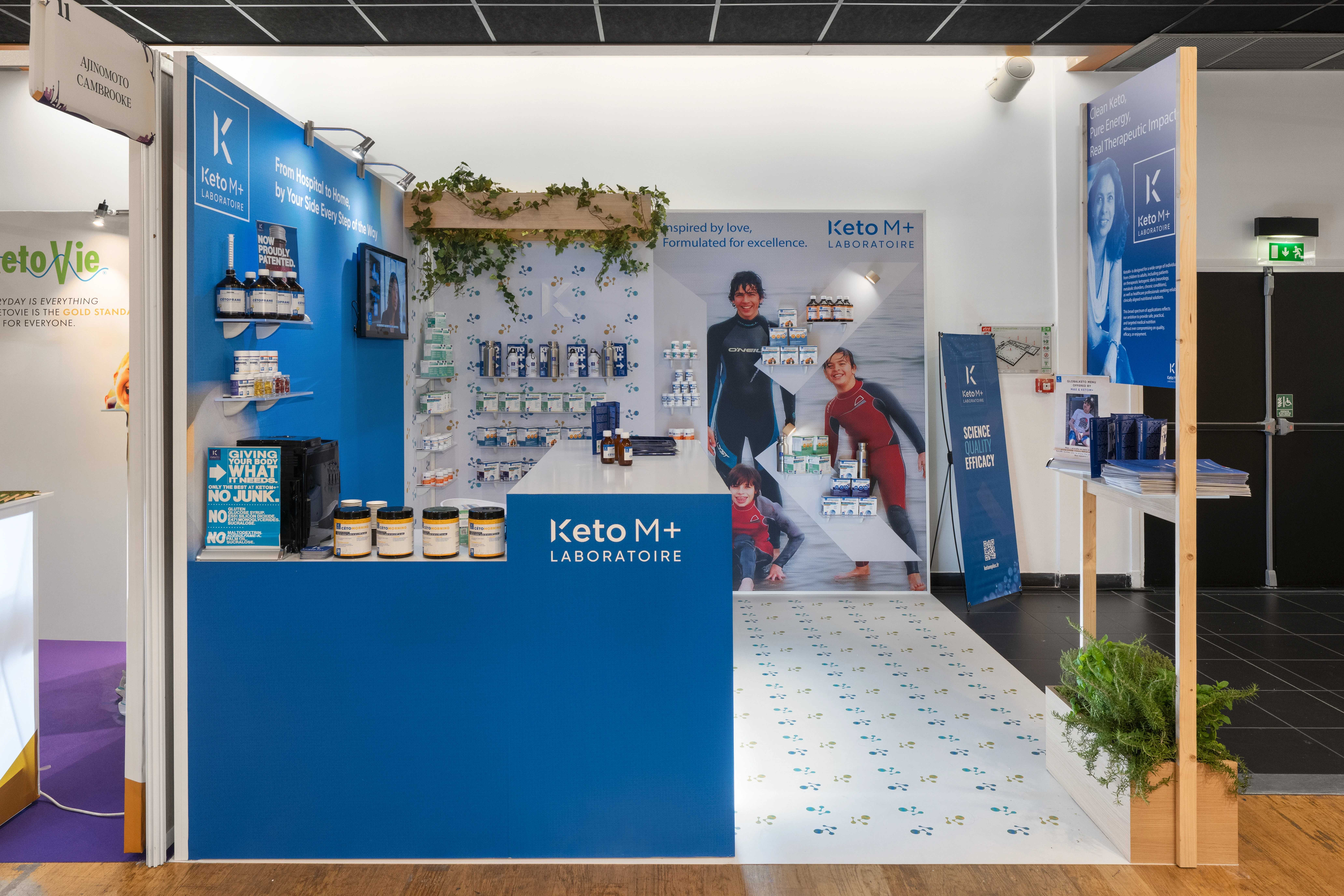 zone centrale du stand Keto M+ 2025 avec étagères produits et visuel grand format