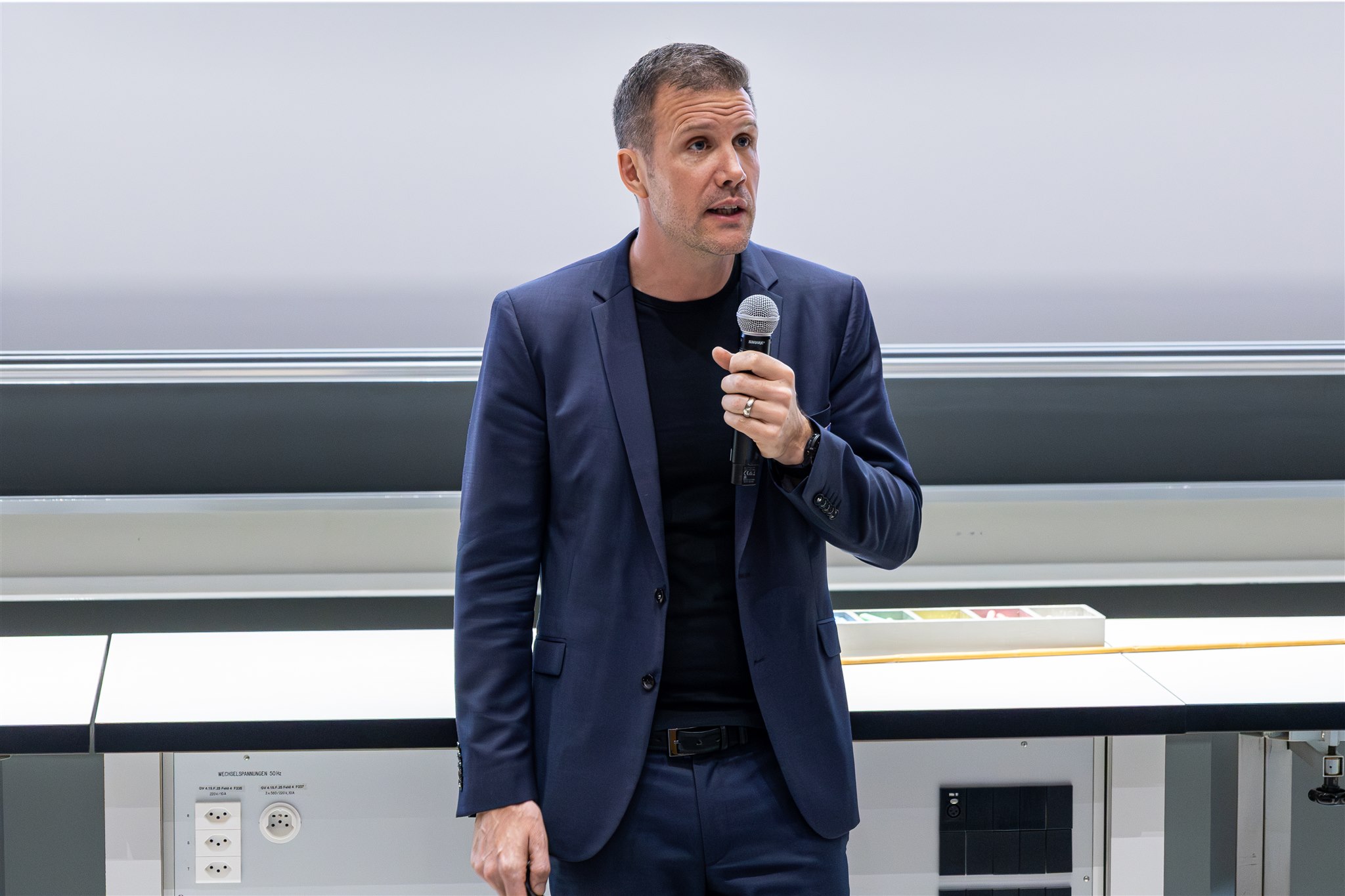 Speaker presenting with microphone at EthereumZüri conference in Zurich lecture hall