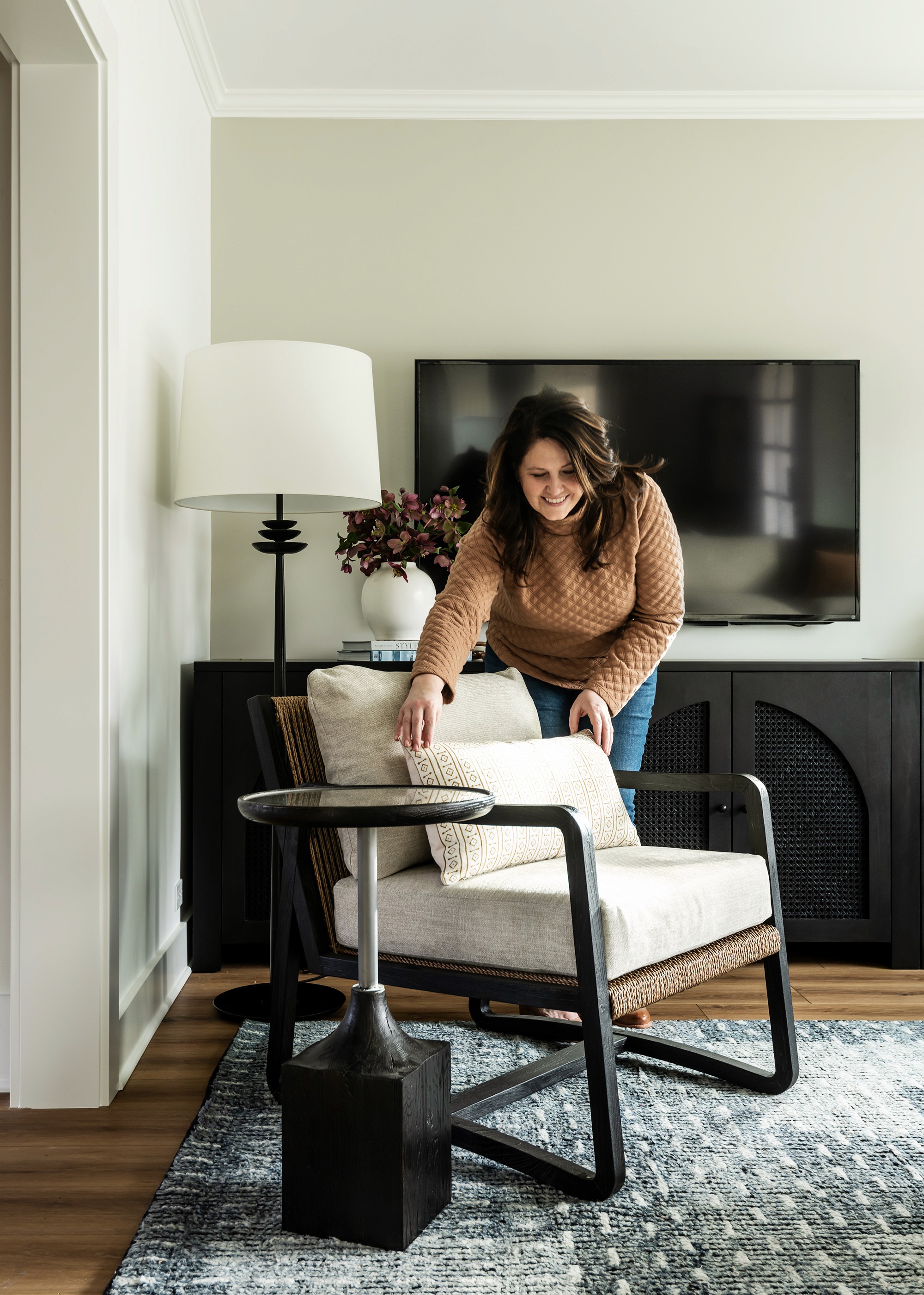 Sherri Monte fluffing a pillow in The living room of The Beacon Hill House remodel by interior designer + professional organizer, Sherri Monte of Elegant Simplicity.