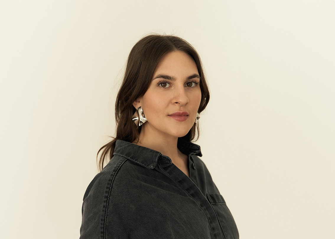 Ein seitliches Portrait vor weißer Wand von Brand Designerin und Nachhaltigkeitsexpterin Leonie Ringeler
