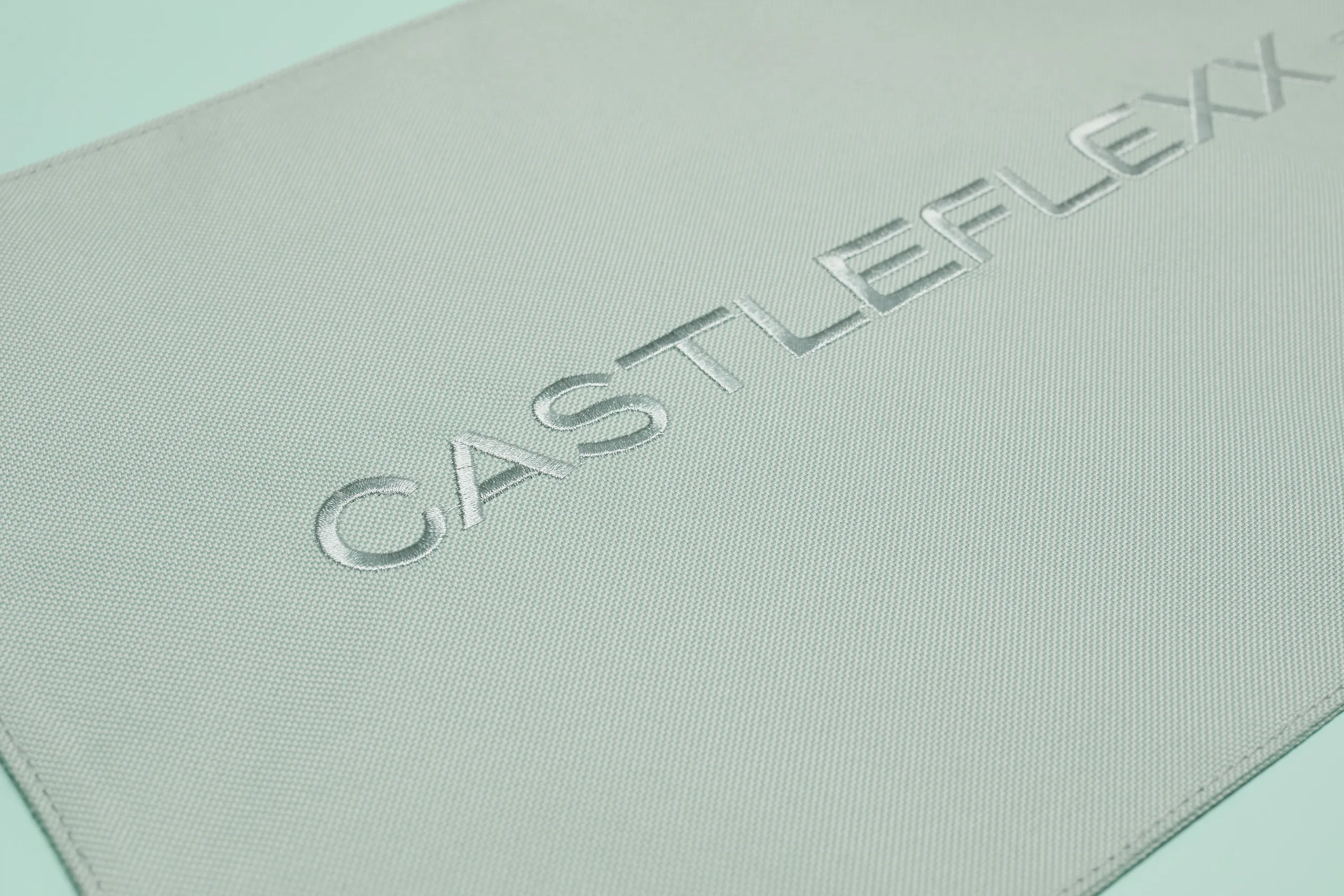 Close-up of the CastleFlexx logo embroidered into the textured fabric strap
