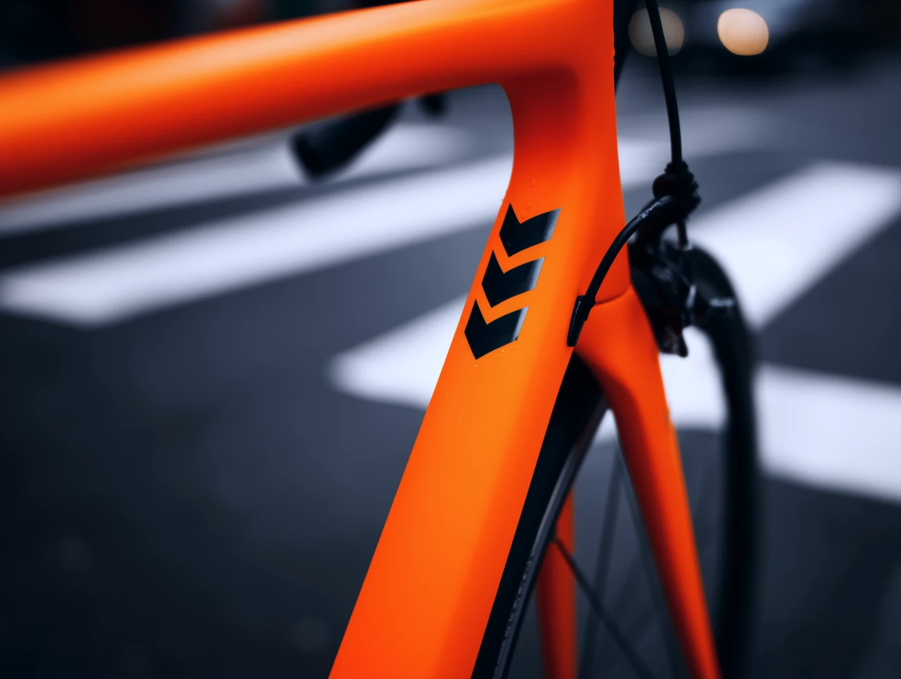 Close-up detail of the orange North bike frame showing branding and precision engineering.