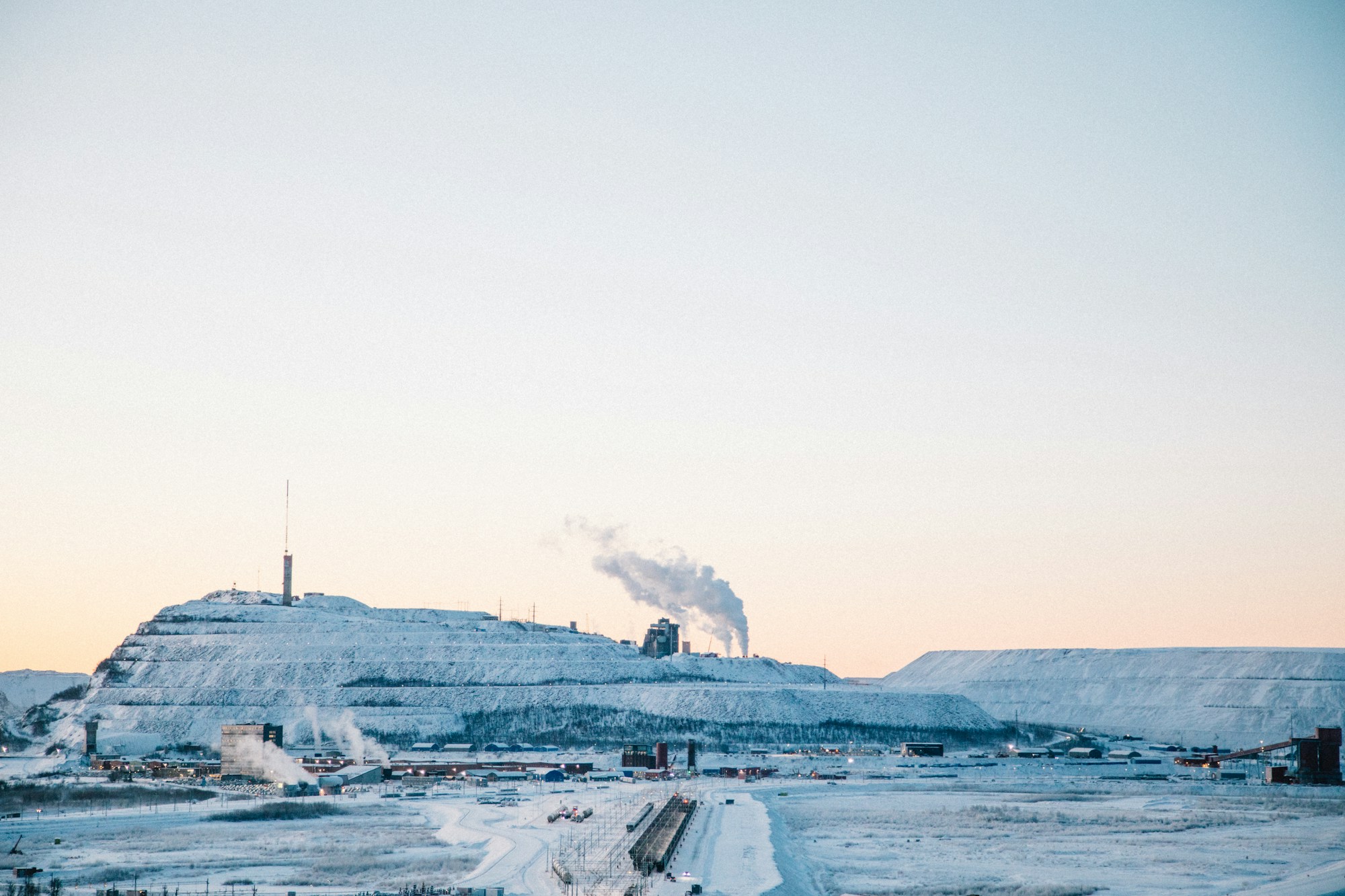 A pellet plant on a snowy plain at dusk