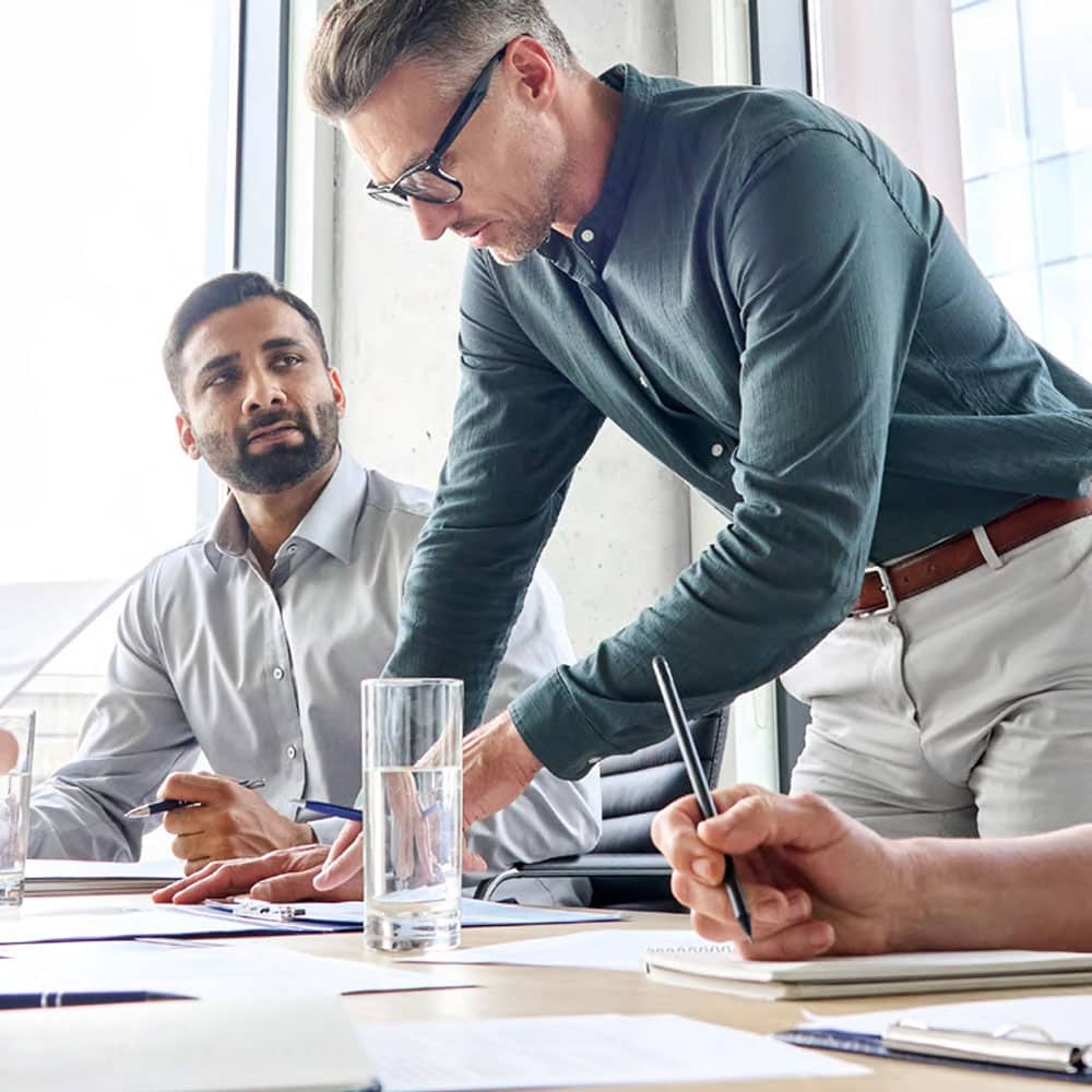 Bild von zwei Personen, die an einem Desk arbeiten