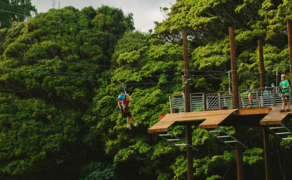 girl ziplining in Oahu through the tree canopy