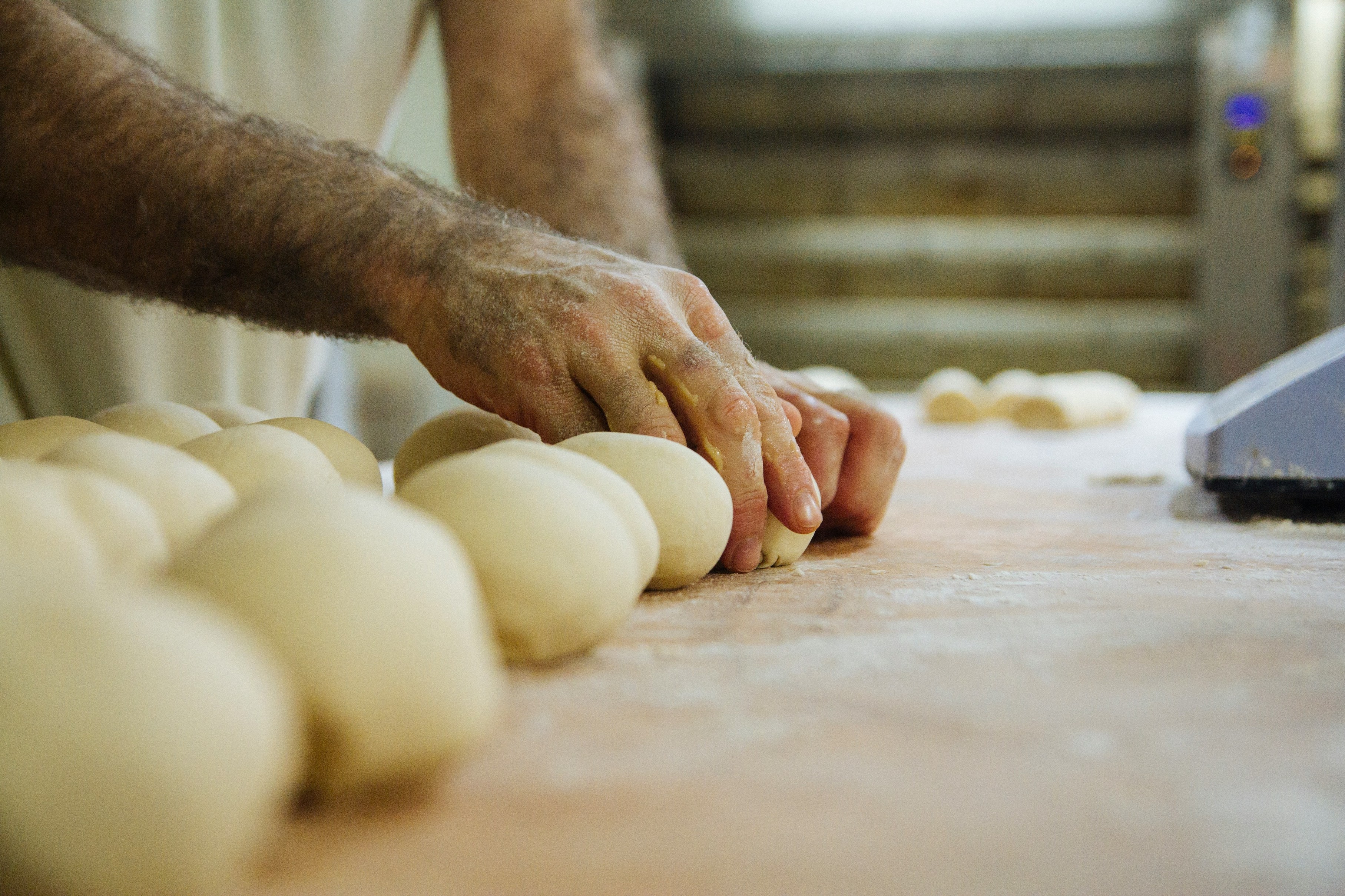 A Baker Rolling Brioche Rolls by Hand