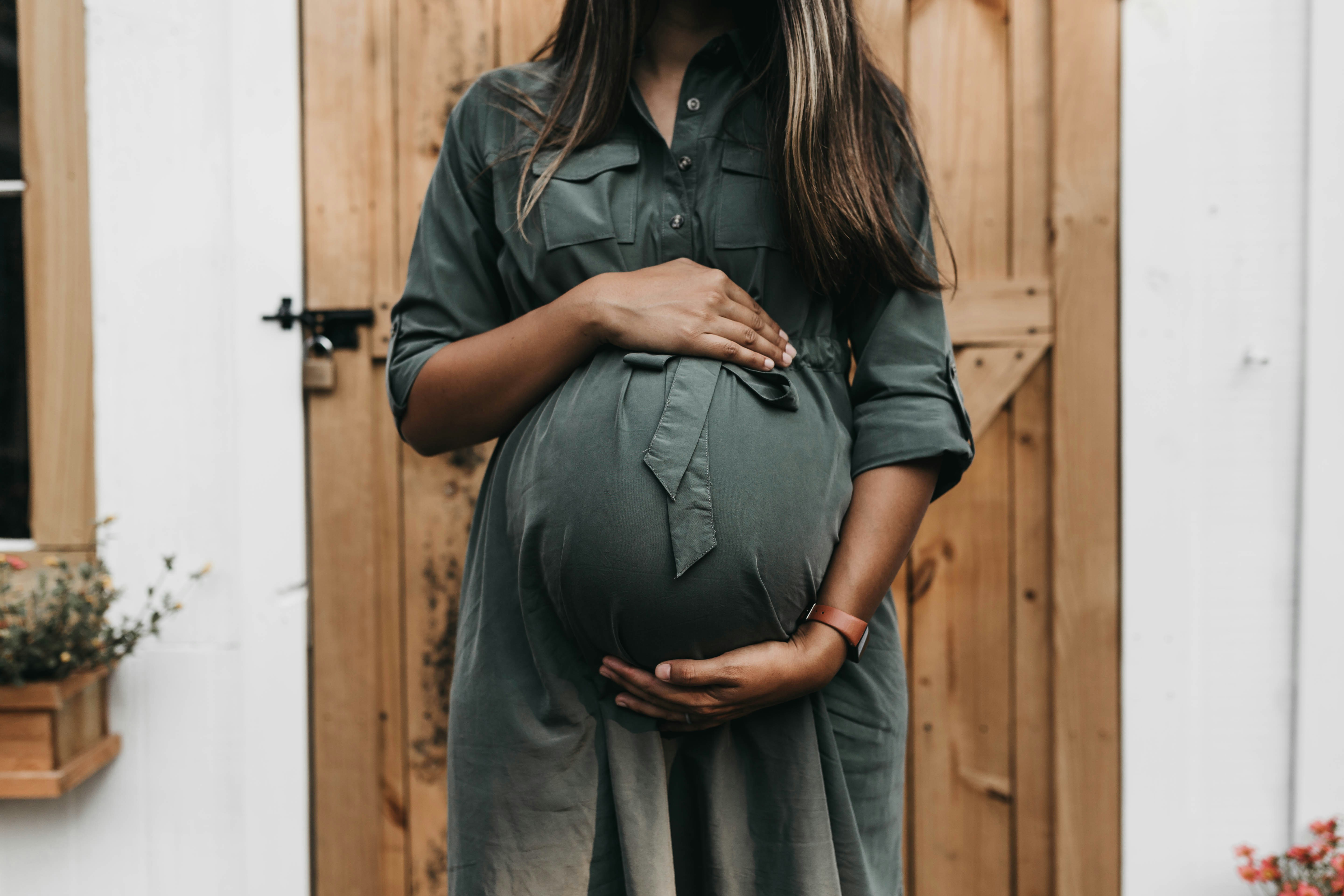 woman standing by the door - Fall Pregnancy Outfits