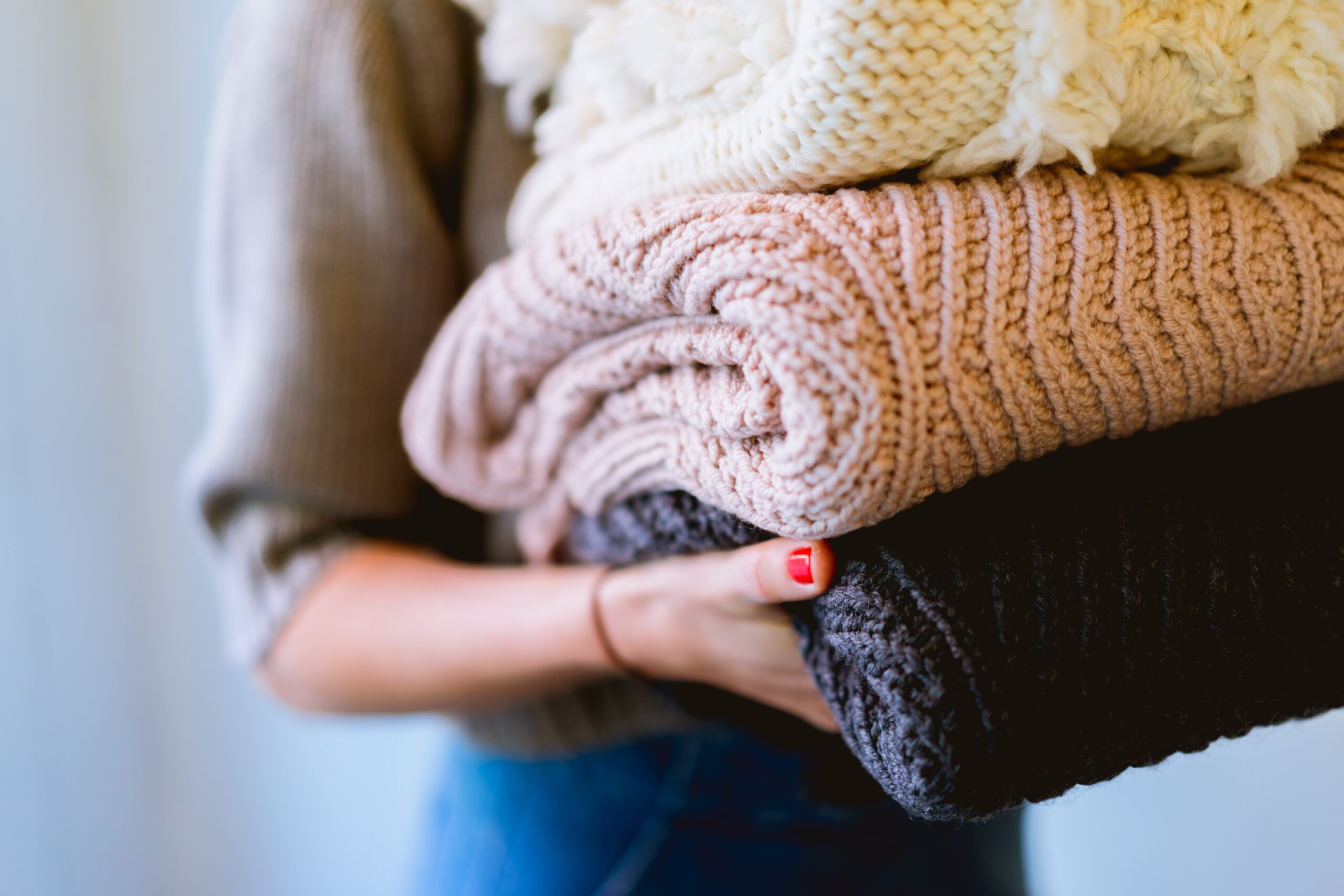 Person holding a few jumpers