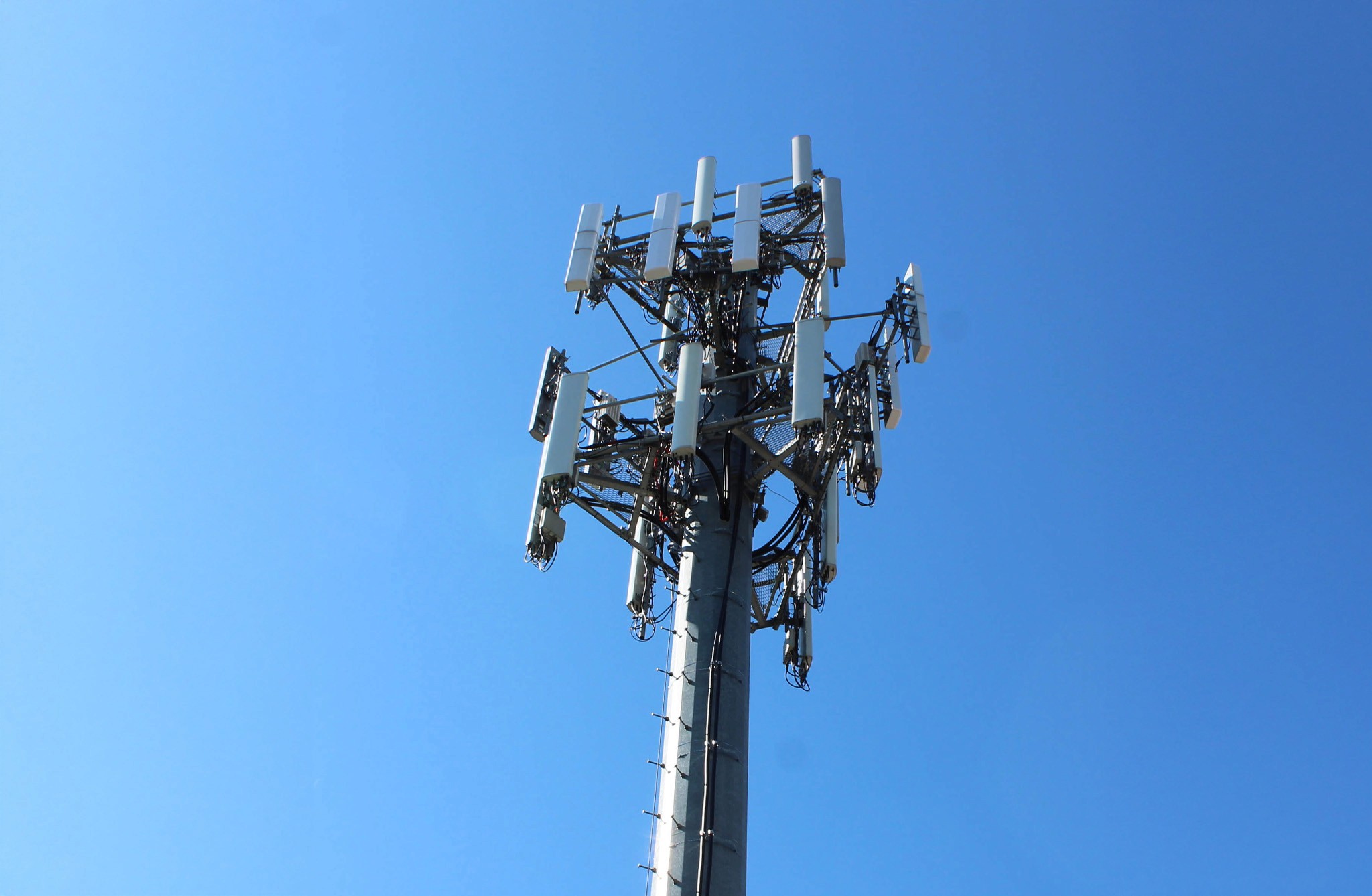 Top of a cell tower. It's a starry night. The lights are on.