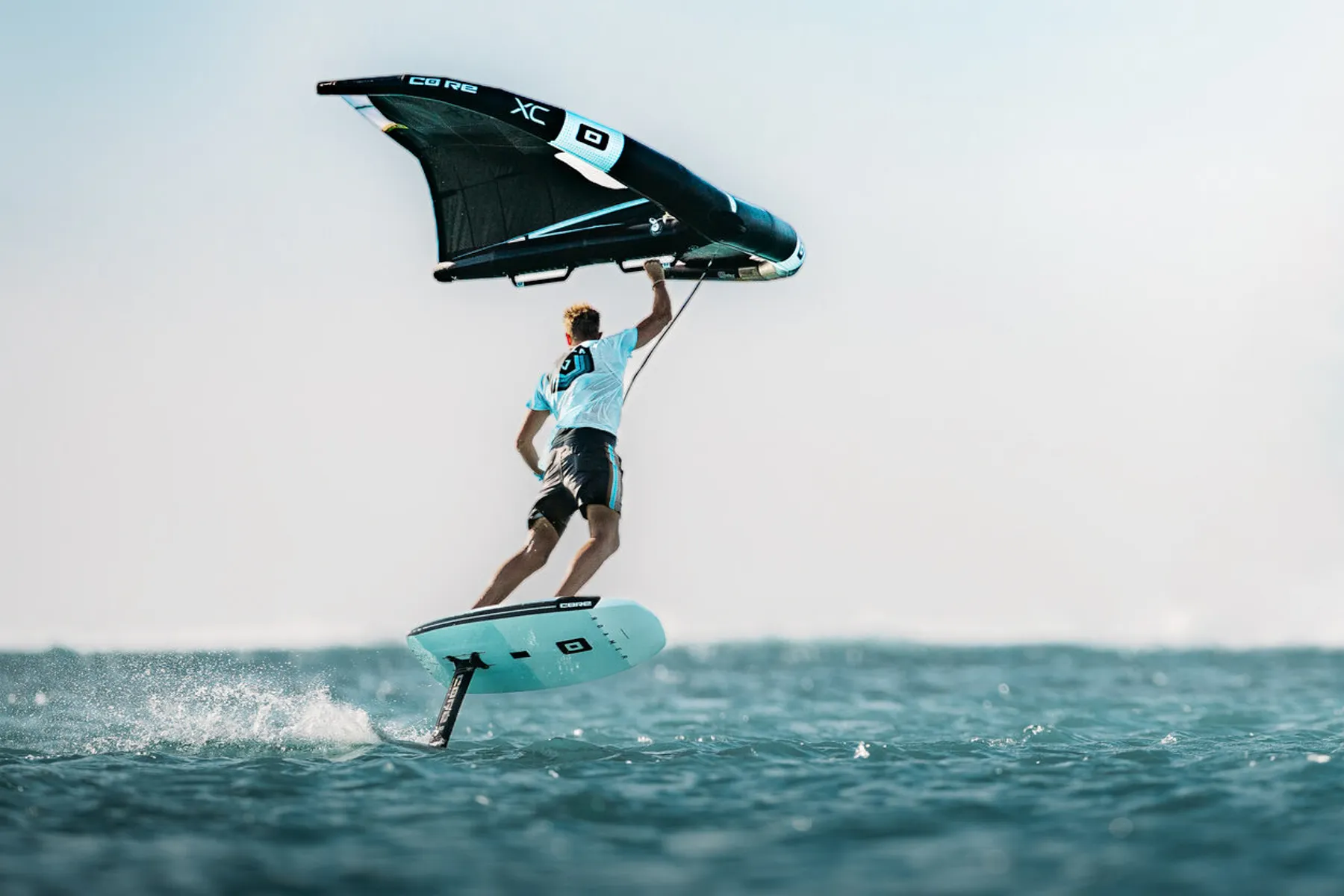 Rider wingfoiling over ocean waves using Core Wing gear for high-performance water sports
