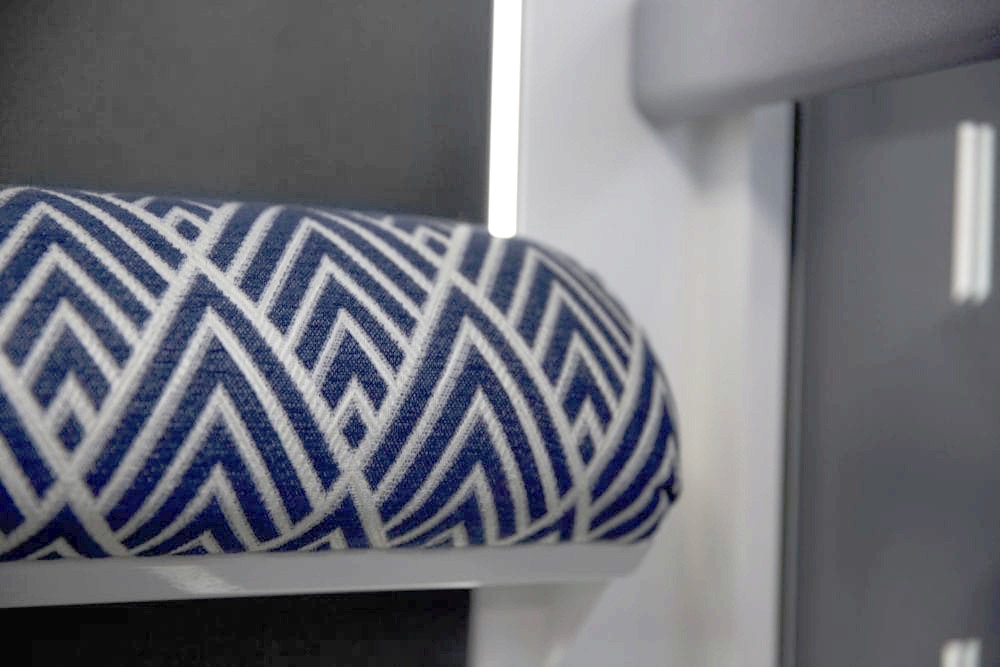 Close-up of the upholstered fold-down seat inside an Elevate AVA Swift homelift cabin, featuring a navy and white geometric patterned fabric