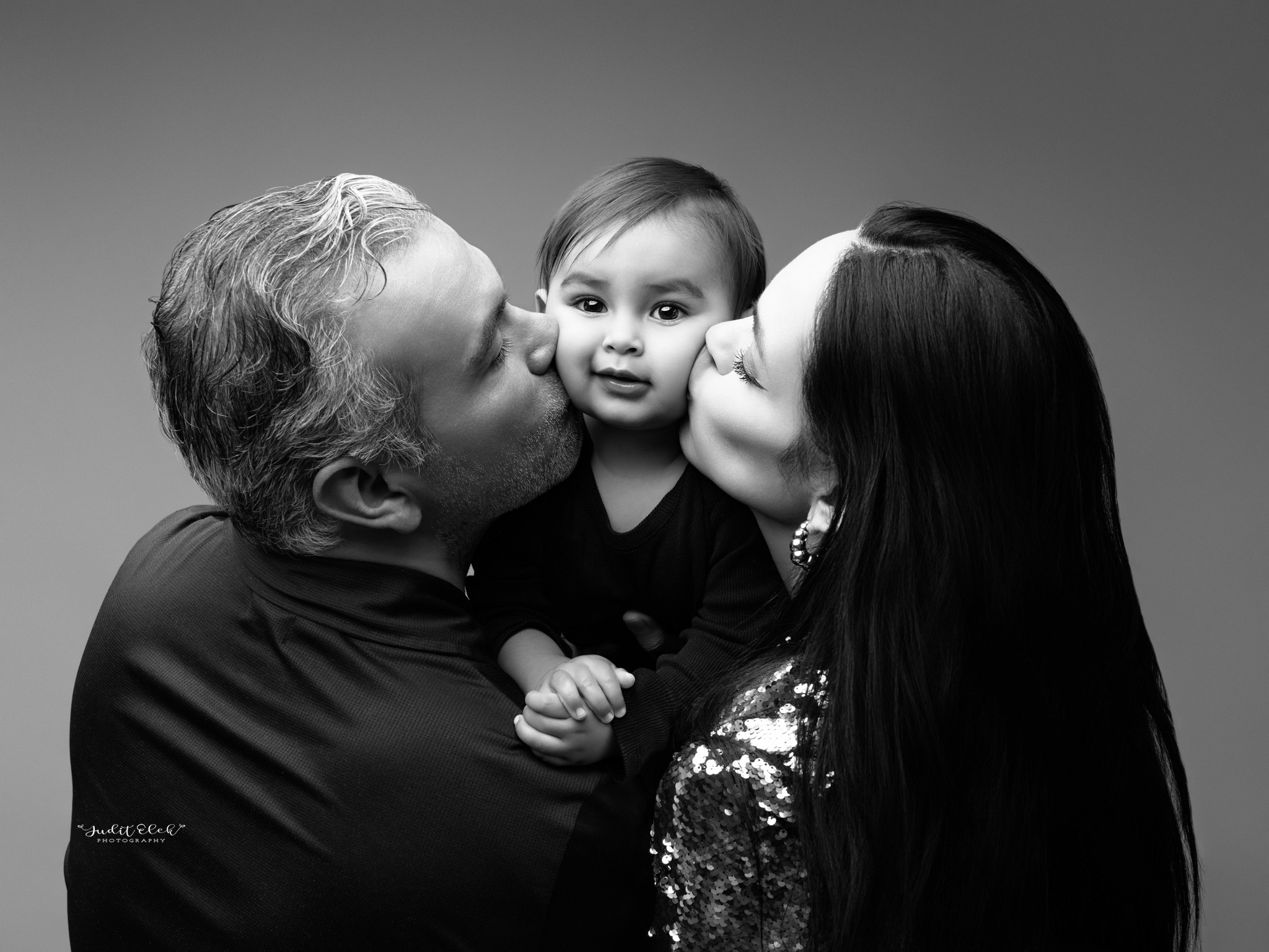 retrato familiar en estudio fotográfico que muestra conexión y amor entre padres e hijo