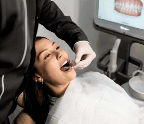 Orthodontist fitting a teeth retainer for a woman