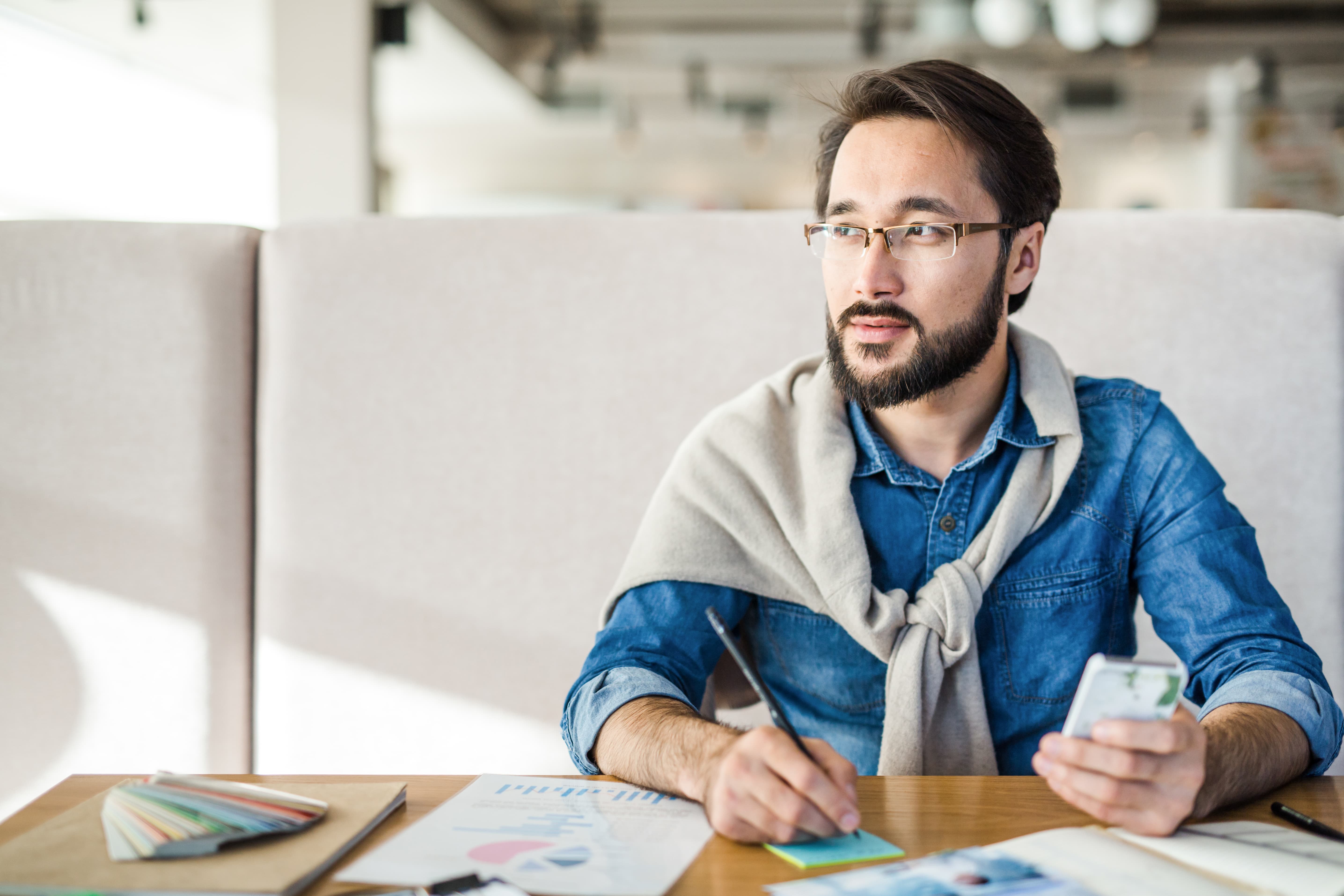 a wide shot of an asian man at a desk