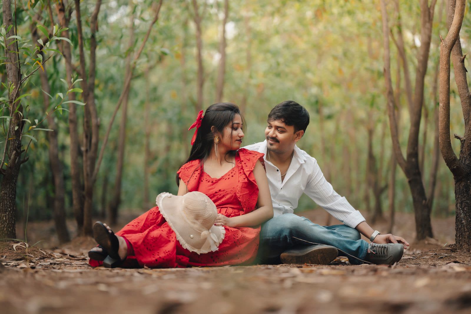 Couple leaning together and smiling in a forest clearing