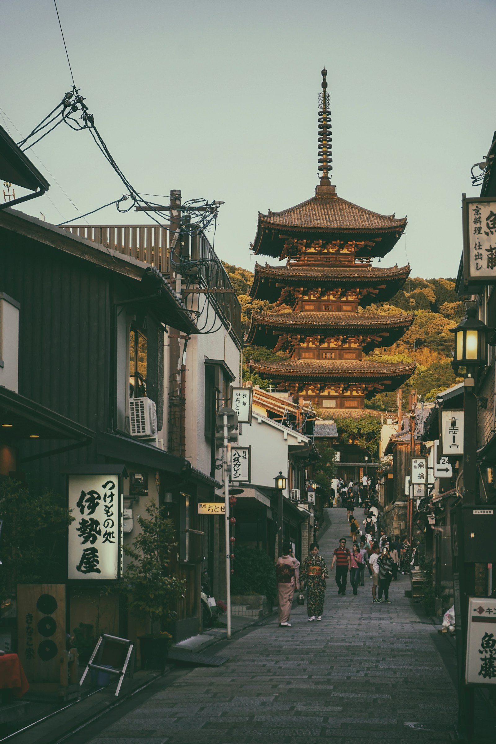 Historic Kyoto street with the Yasaka Pagoda rising above traditional Japanese buildings at dusk