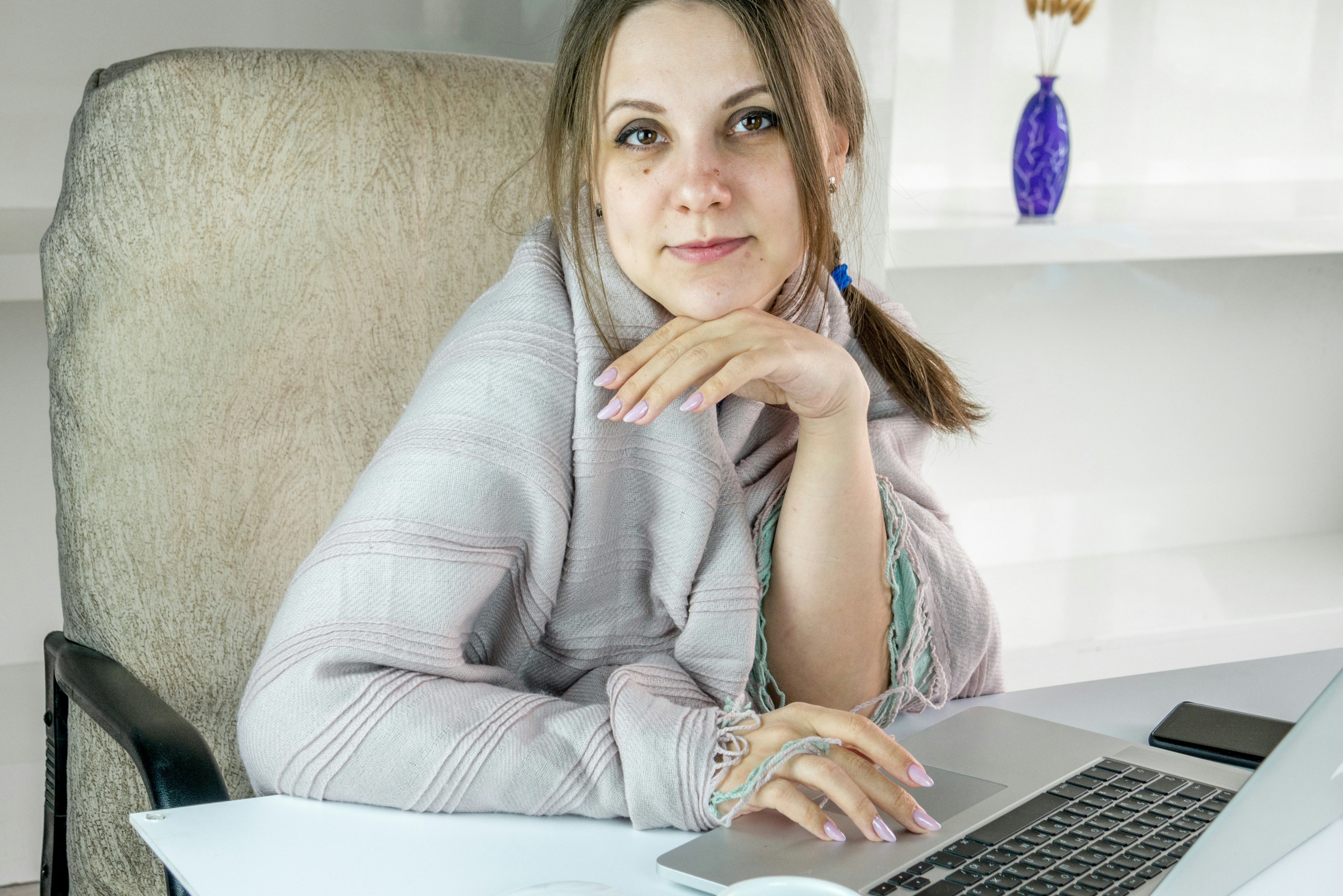 a woman sitting in front of a laptop computer