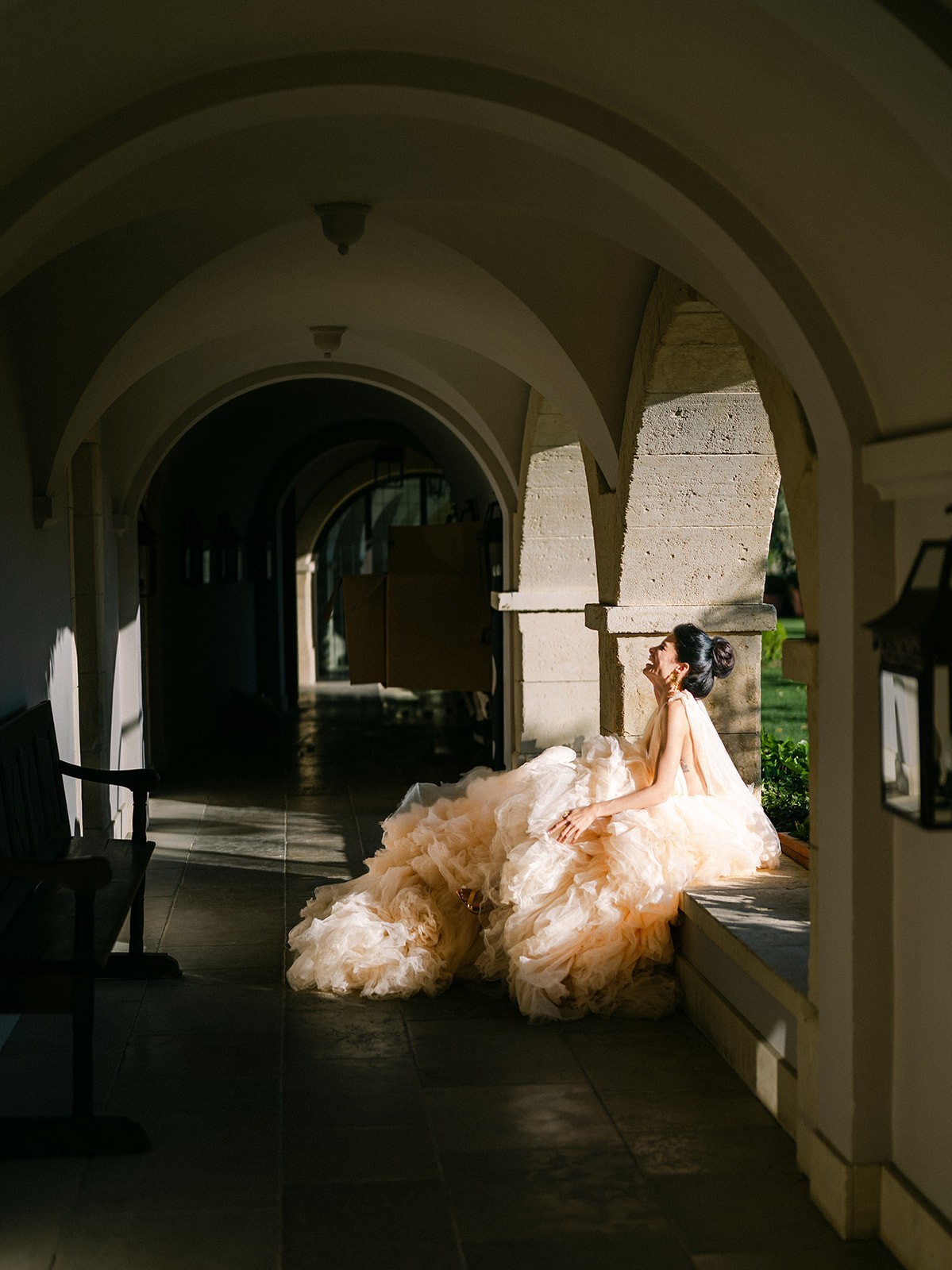 A bride in a lace wedding dress gently holds.