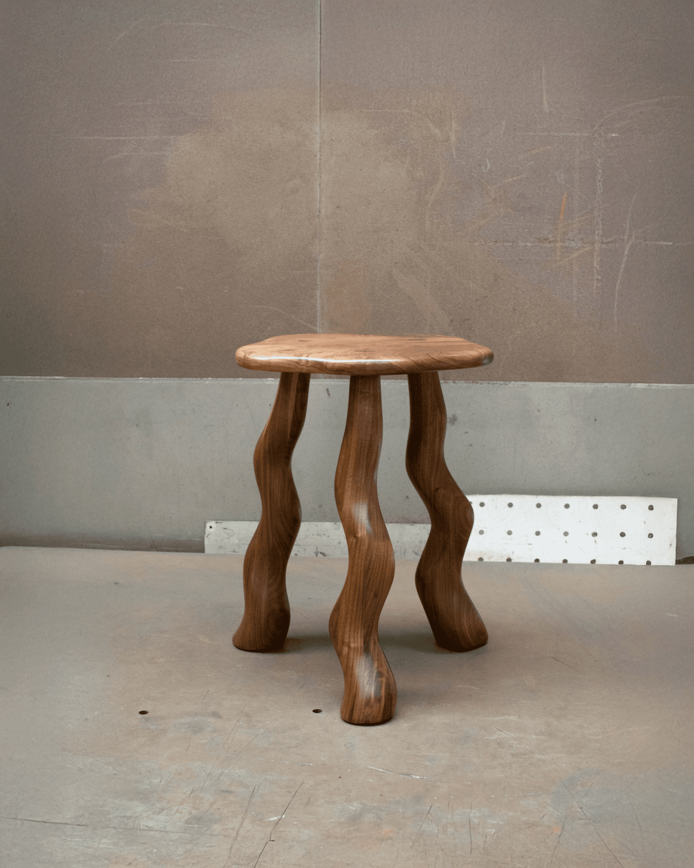Dancing Stool in Walnut with carved wavy legs by Wilkinson & Rivera.