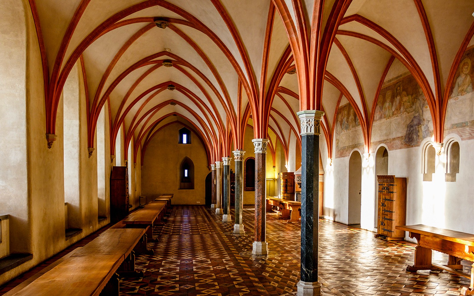 Malbork Castle interior with vaulted ceilings and medieval decor.