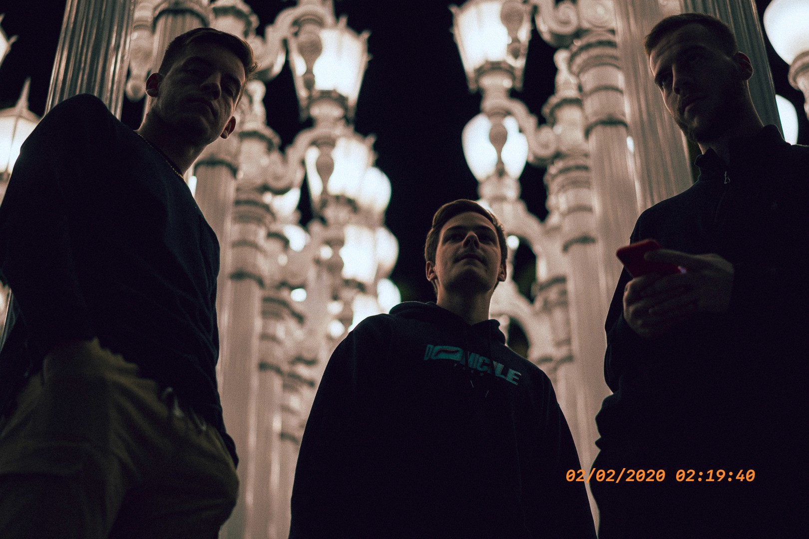 Groupe d’amis de nuit parmi des rangées de lampadaires