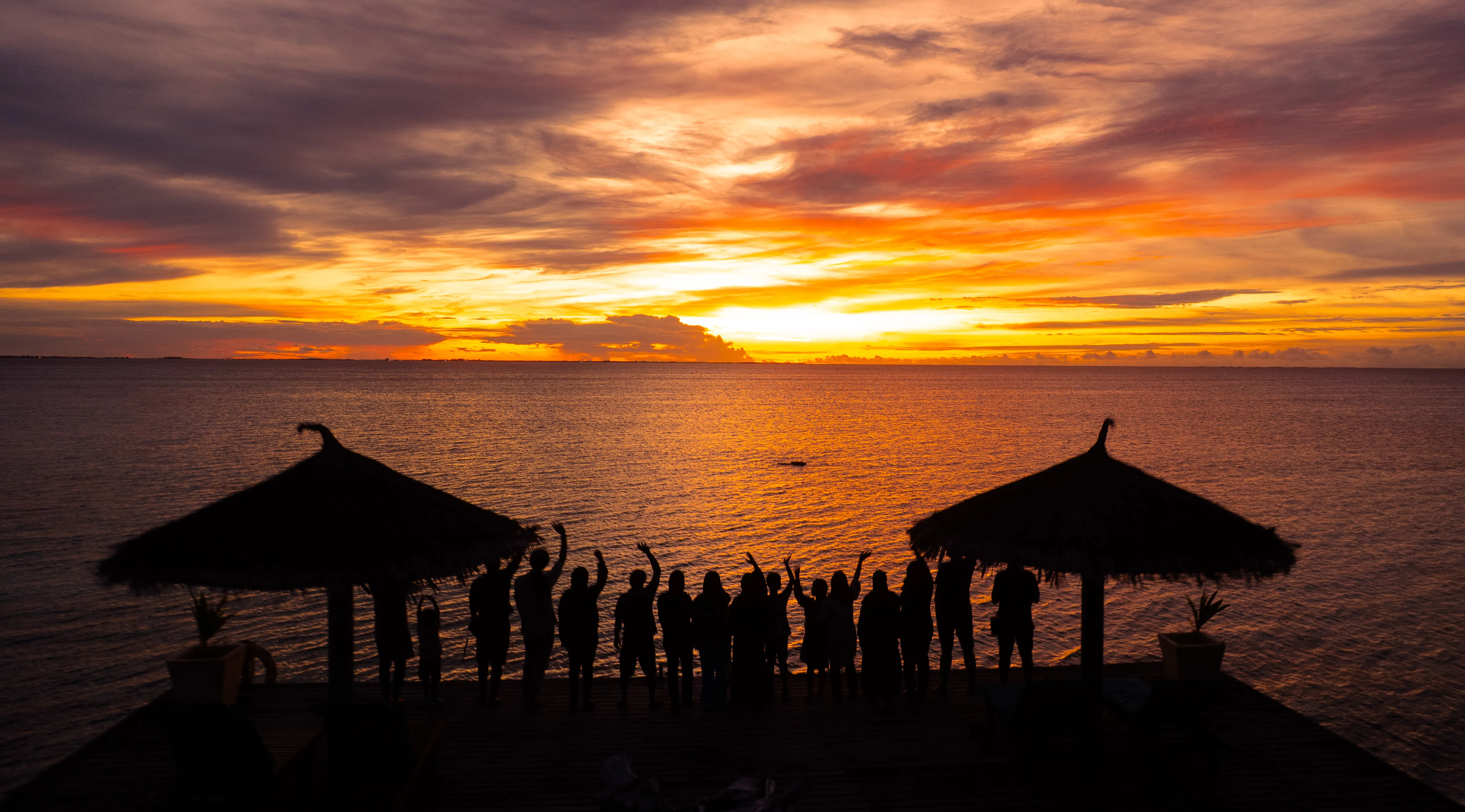 Friends laughing around a campfire in the woods