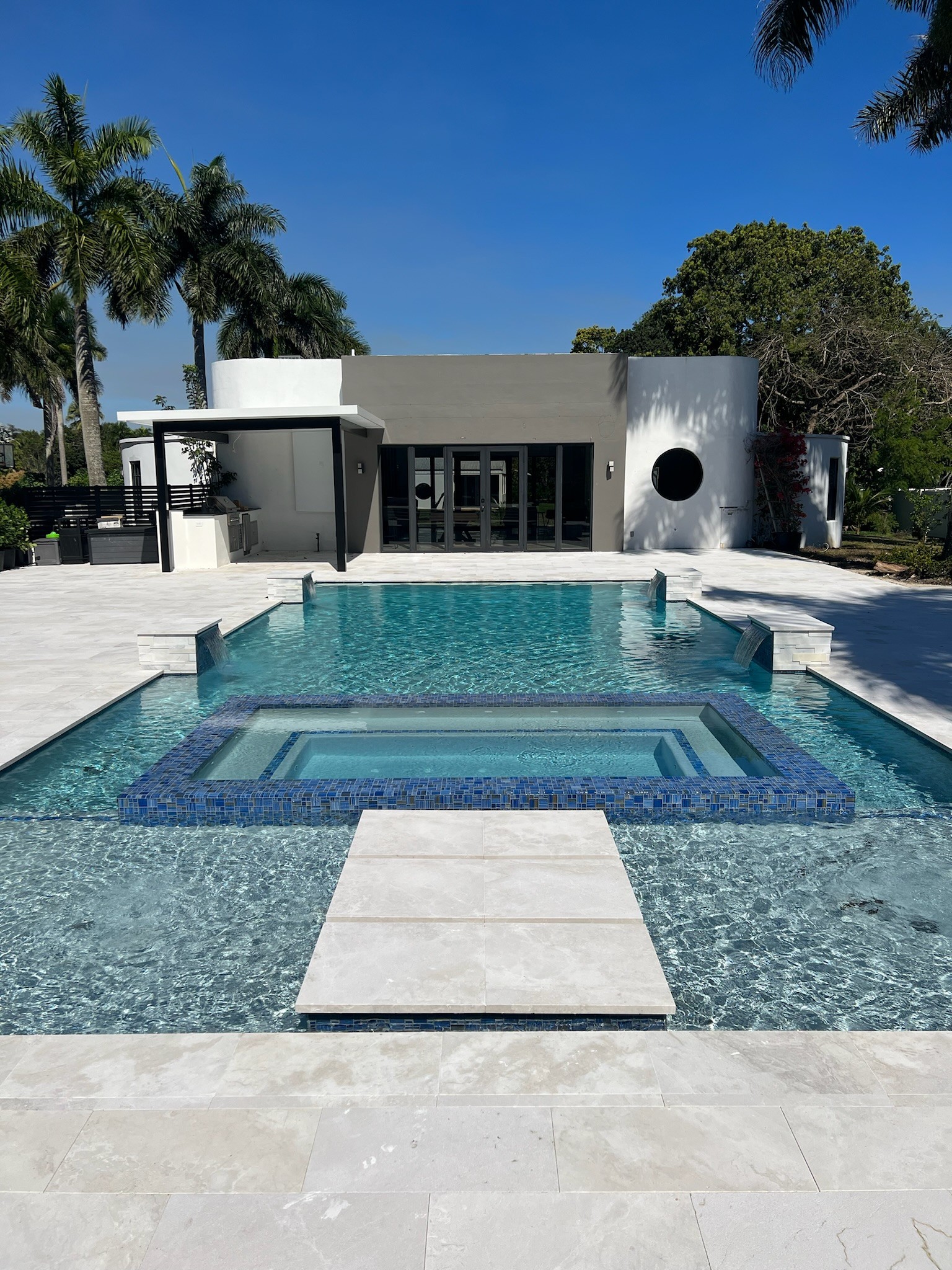 Luxury modern home with infinity pool, spa, and palm trees