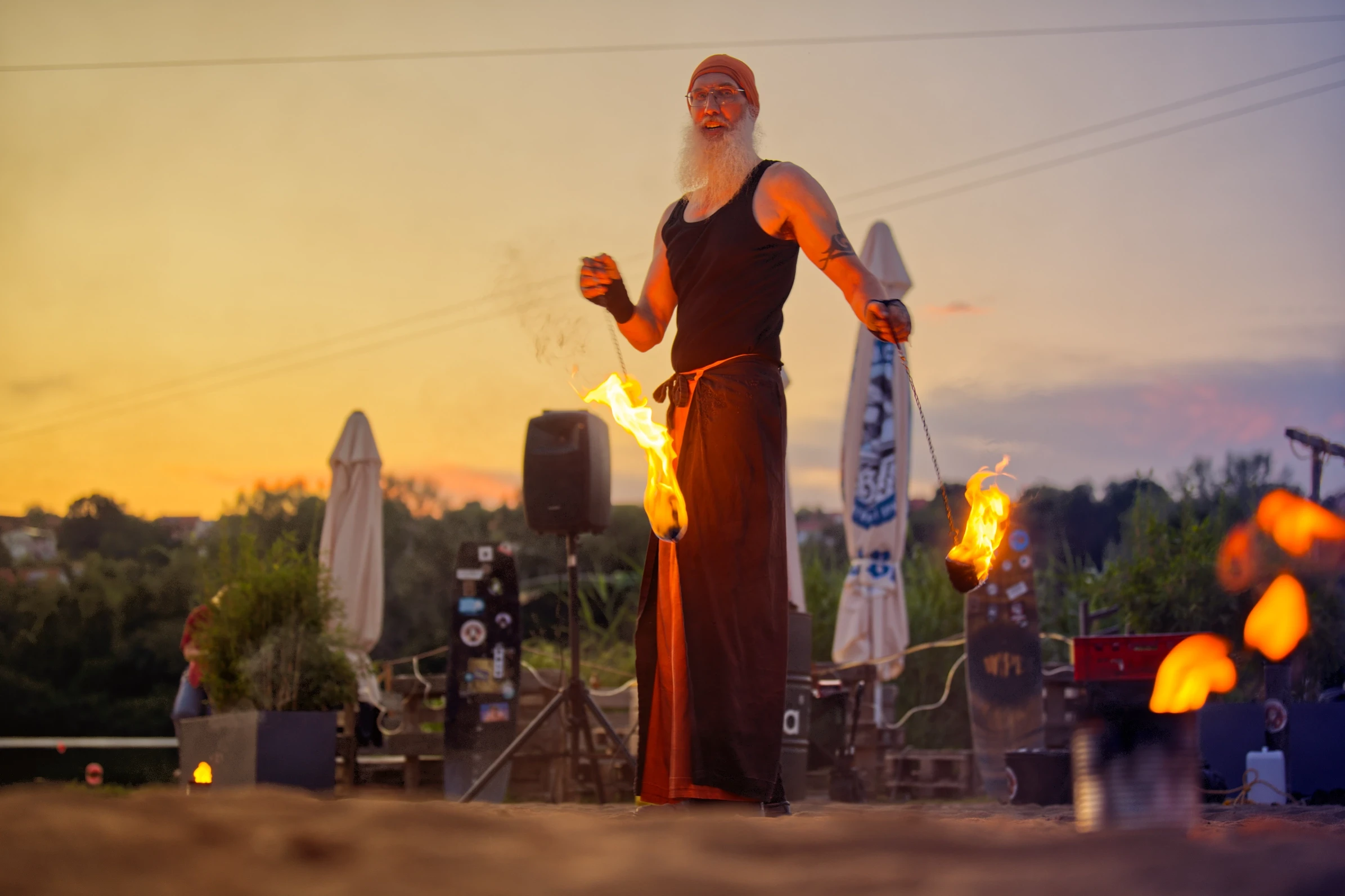 Flammenartist Eberhard Wolter präsentiert eine Feuerperformance bei Sonnenuntergang am Wakepark Brombachsee.