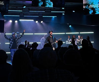 Congregation with hands raised in worship at New Hope Church
