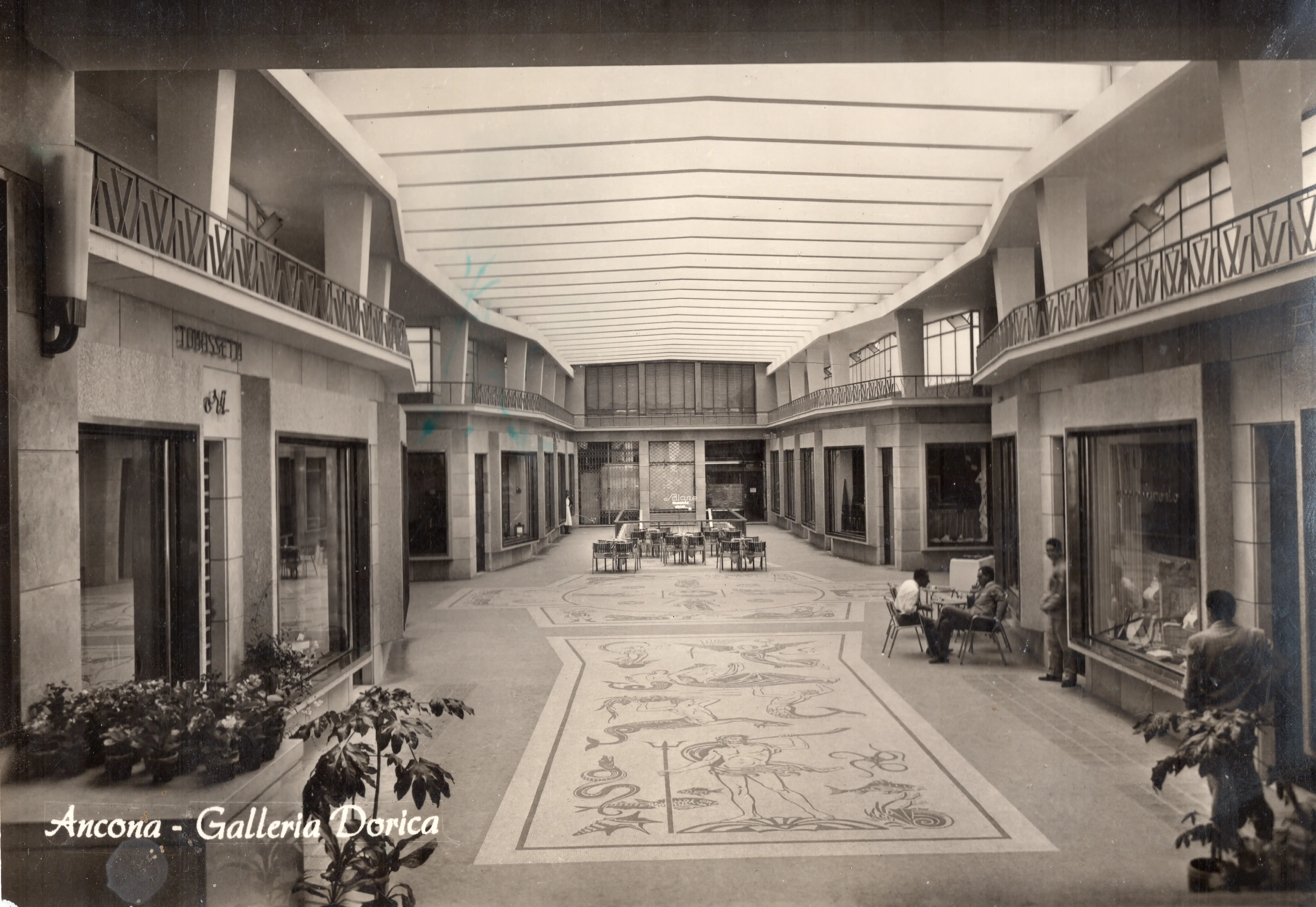 Fotografia storica di Galleria Dorica nel centro di Ancona, luogo legato alla storia e alla presenza di Ottica Dentella. L’immagine d’archivio mostra l’ambiente della galleria commerciale negli anni passati e accompagna il racconto di un’ottica attiva dal 1956, cresciuta ad Ancona attraverso generazioni, innovazione tecnologica, ricerca nell’eyewear, artigianalità e una costante attenzione alla qualità della visione.