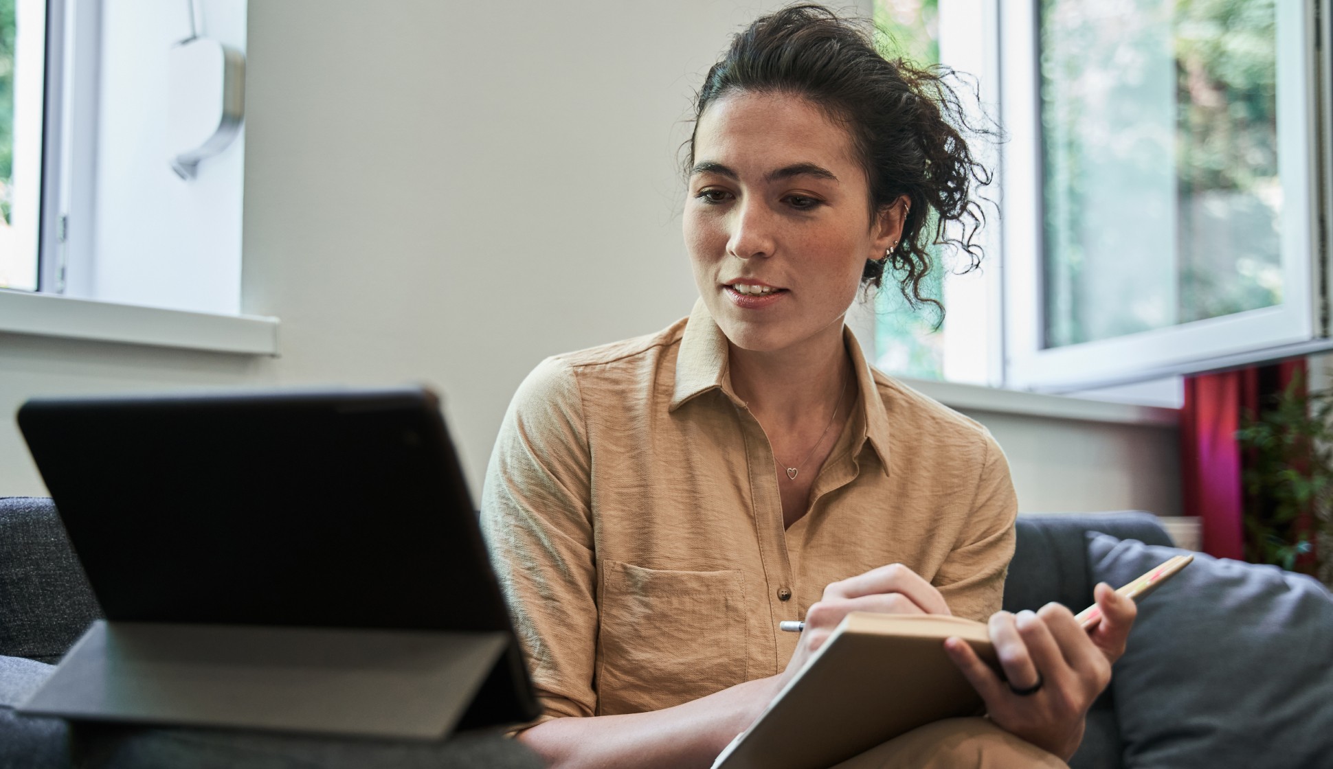 a young female therapist looking at her desktop while taking notes