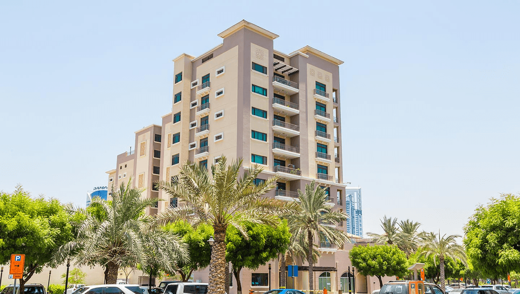 A scenic view of The Greens Community featuring lush greenery, playgrounds, and residents engaging in leisure activities