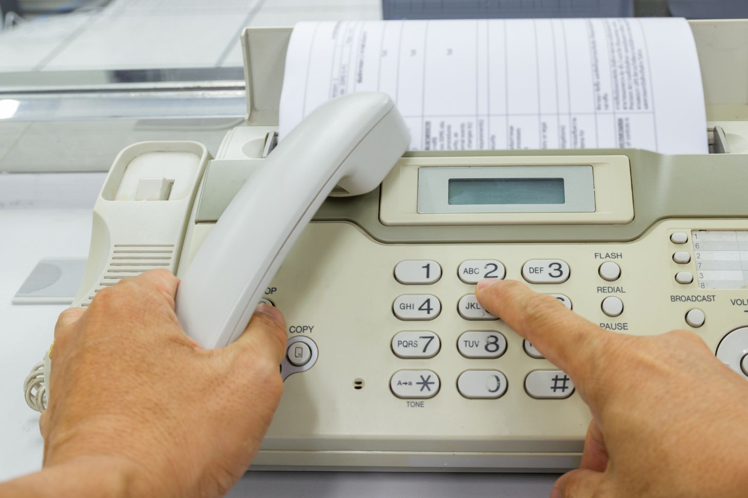 Person are using a fax machine send paper