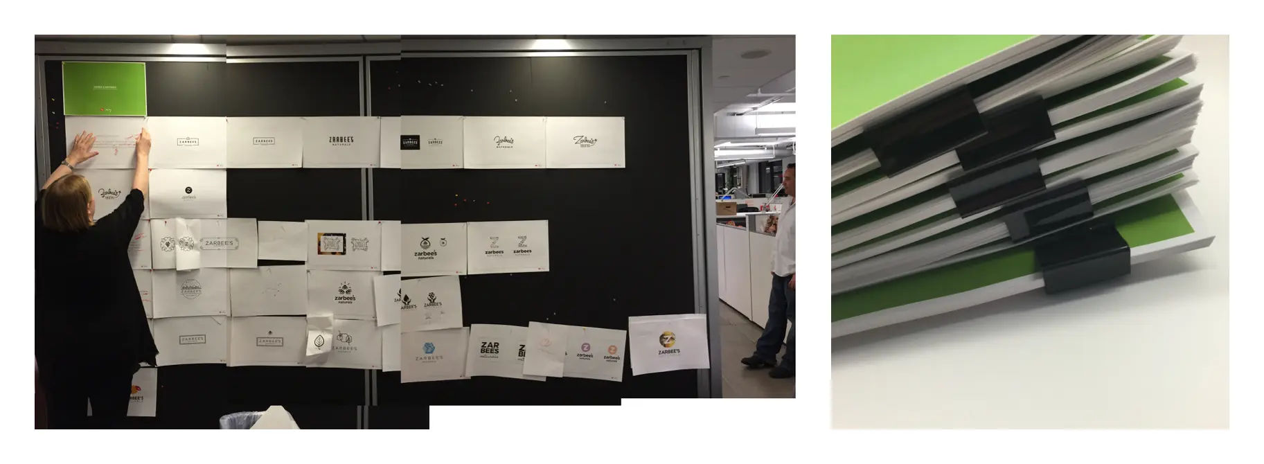 Behind-the-scenes photos from the Zarbee's brand exploration — a team member pinning dozens of printed logo concepts to a black presentation wall alongside a stack of bound presentation decks, showing the volume of work produced during the identity development process.