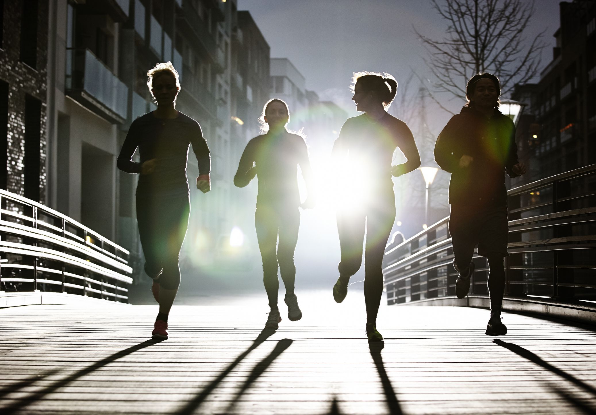 Group of people running in a city at night.