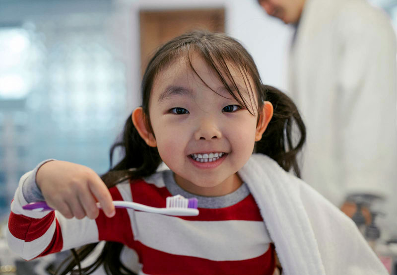 Smiling child holding toothbrush