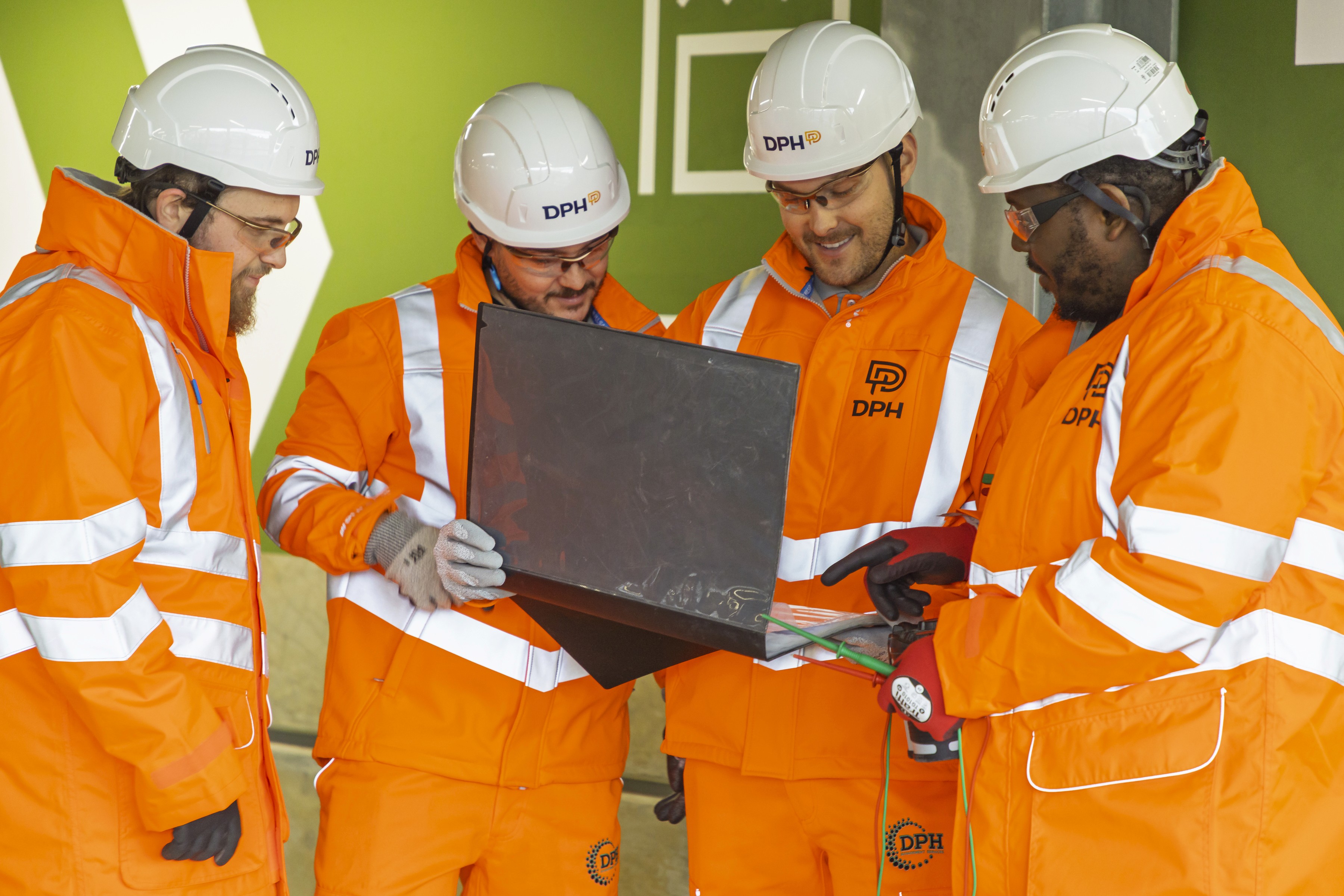 Modern glass building with illuminated interior and reflections at sunset