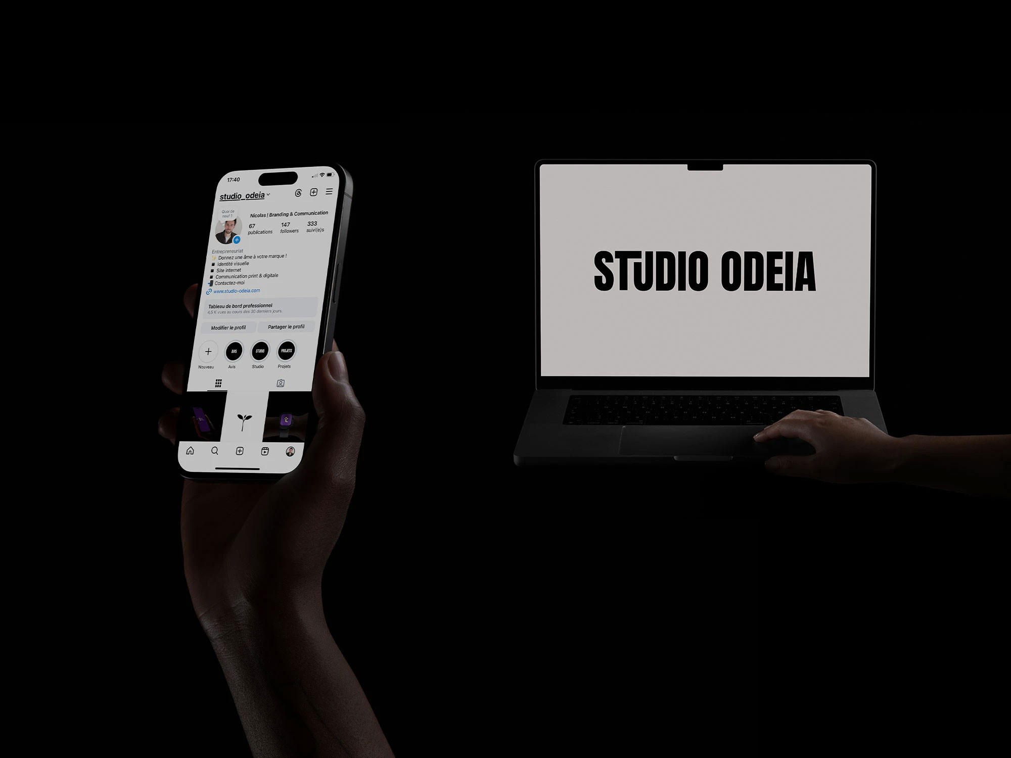 Studio Odeia, un téléphone dans une main avec un compte de réseaux sociaux, et un ordinateur portable ouvert sur un site internet