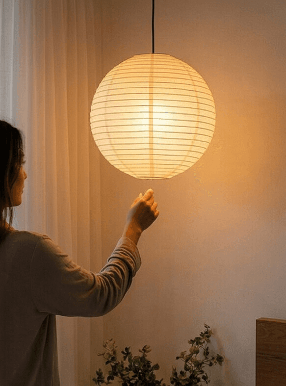 Dämmerung auf dem Balkon einer Eigentumswohnung in Remshalden. Eine Frau schaltet die Ballonlampe im Schlafzimmer an und schafft eine stimmungsvolle Atmosphäre für den Abend.