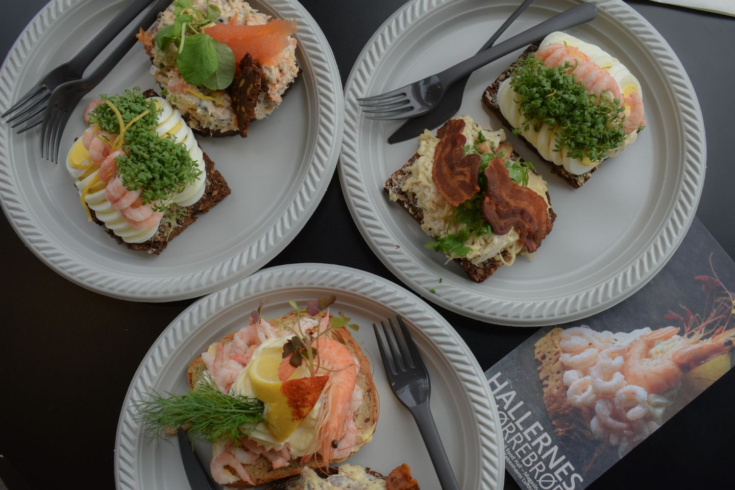 Traditional Nordic smørrebrød with shrimp, smoked salmon, eggs, and bacon served at a restaurant in Reykjavík.