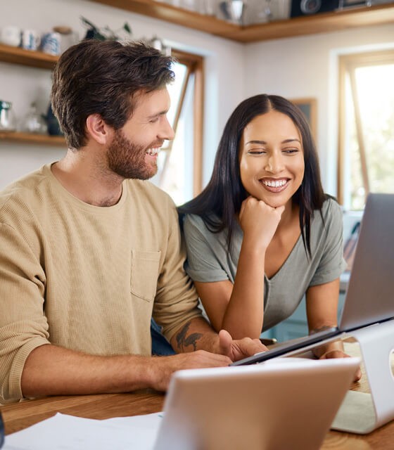 a couple happily looking over their computer