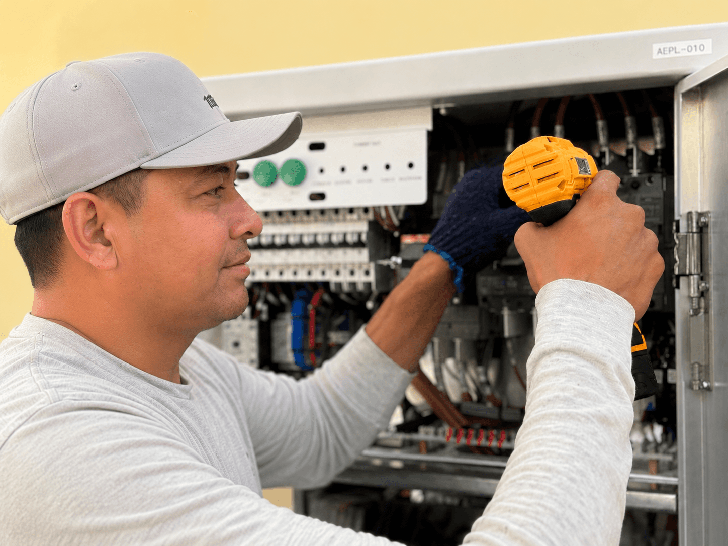Electrician on ladder wiring modern multi-arm ceiling light fixture during home installation