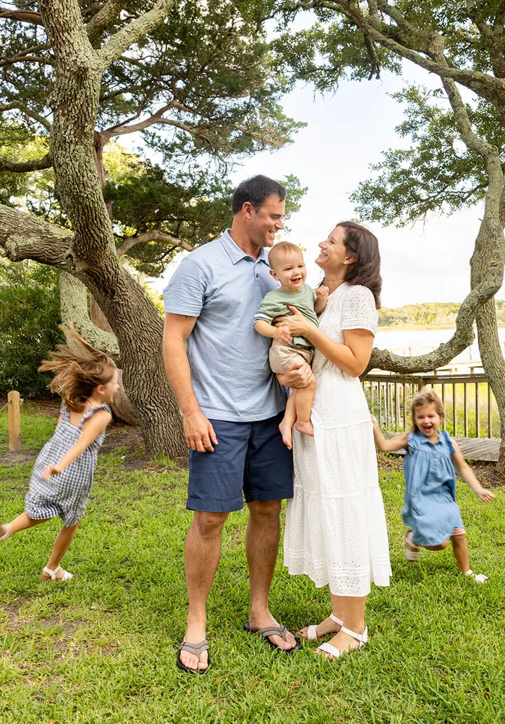 Family with three young kids laughing together under an oak tree, by Sioux Falls, SD family photographer Kelsey Lynn