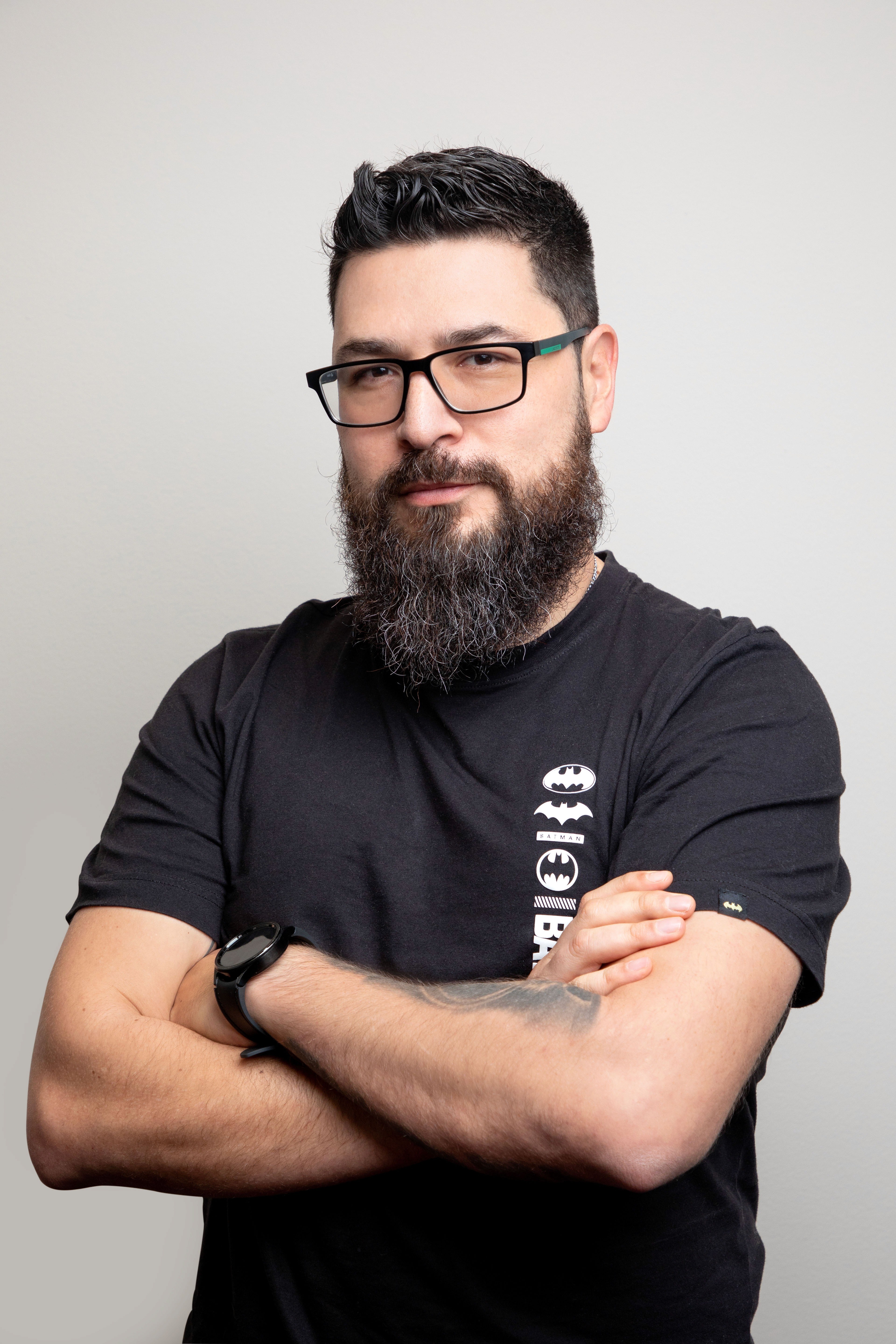 muscular man in glasses smiling and folding arms